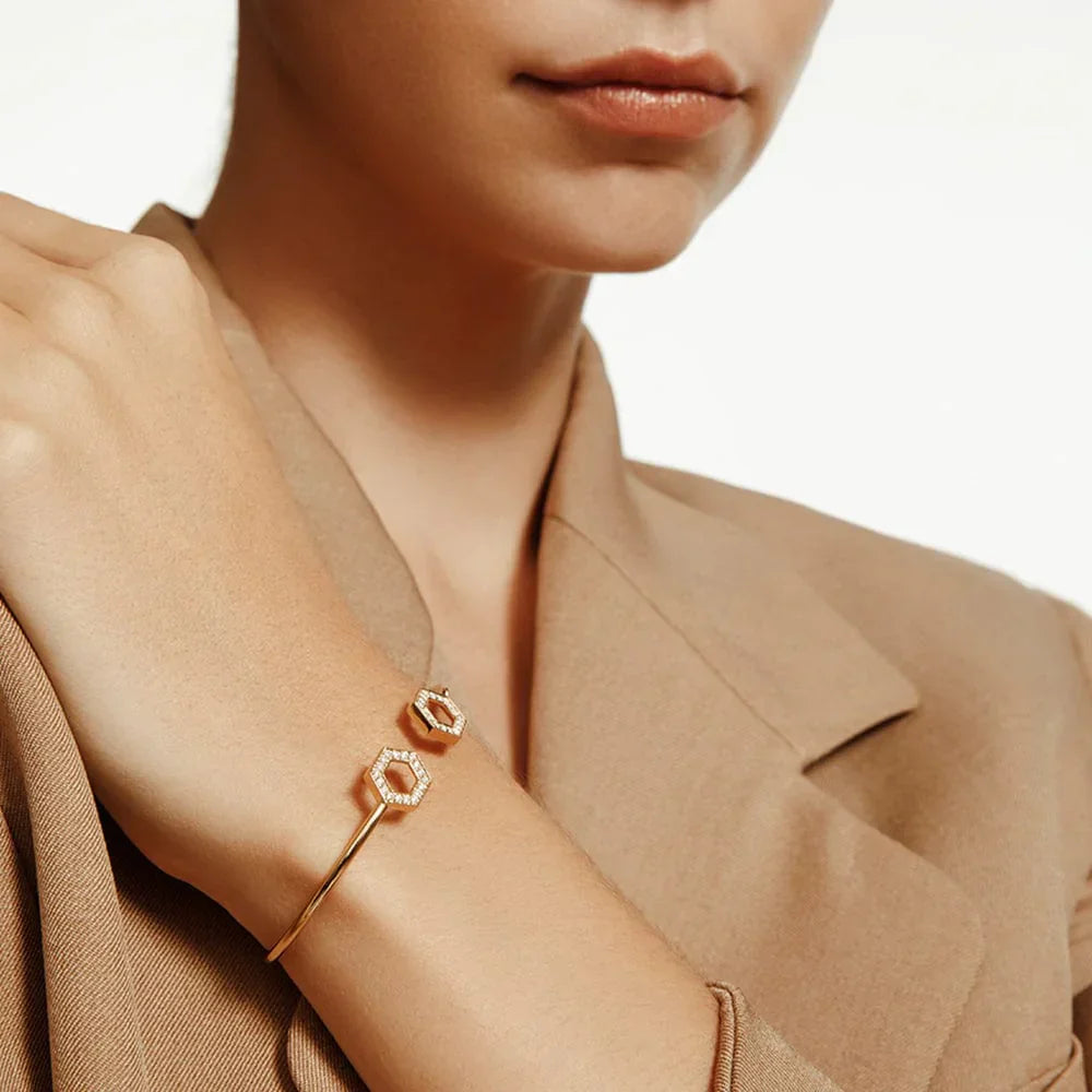 Woman wearing yellow gold cuff bracelet with diamond hexagon accents