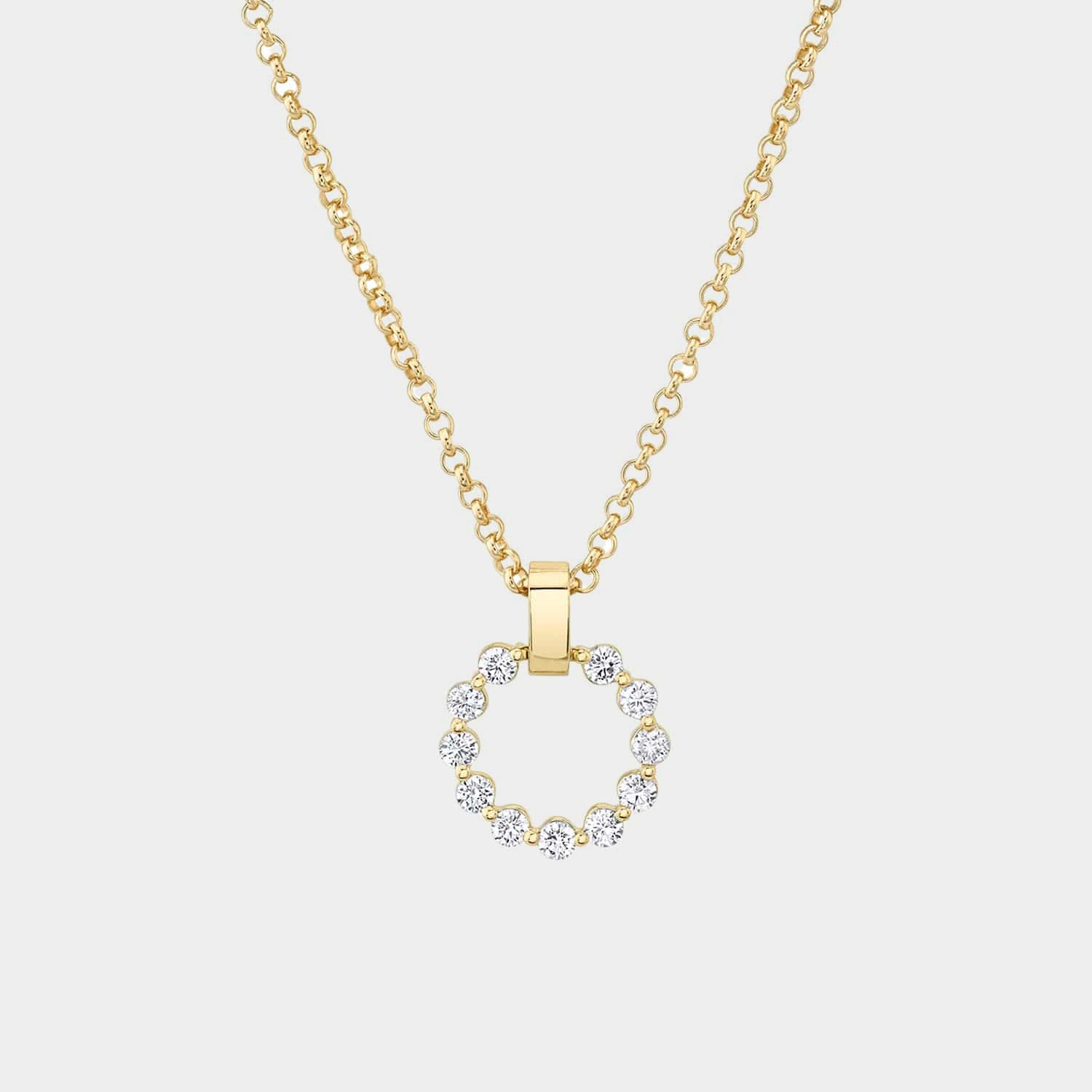 Yellow gold circular diamond pendant necklace on grey background