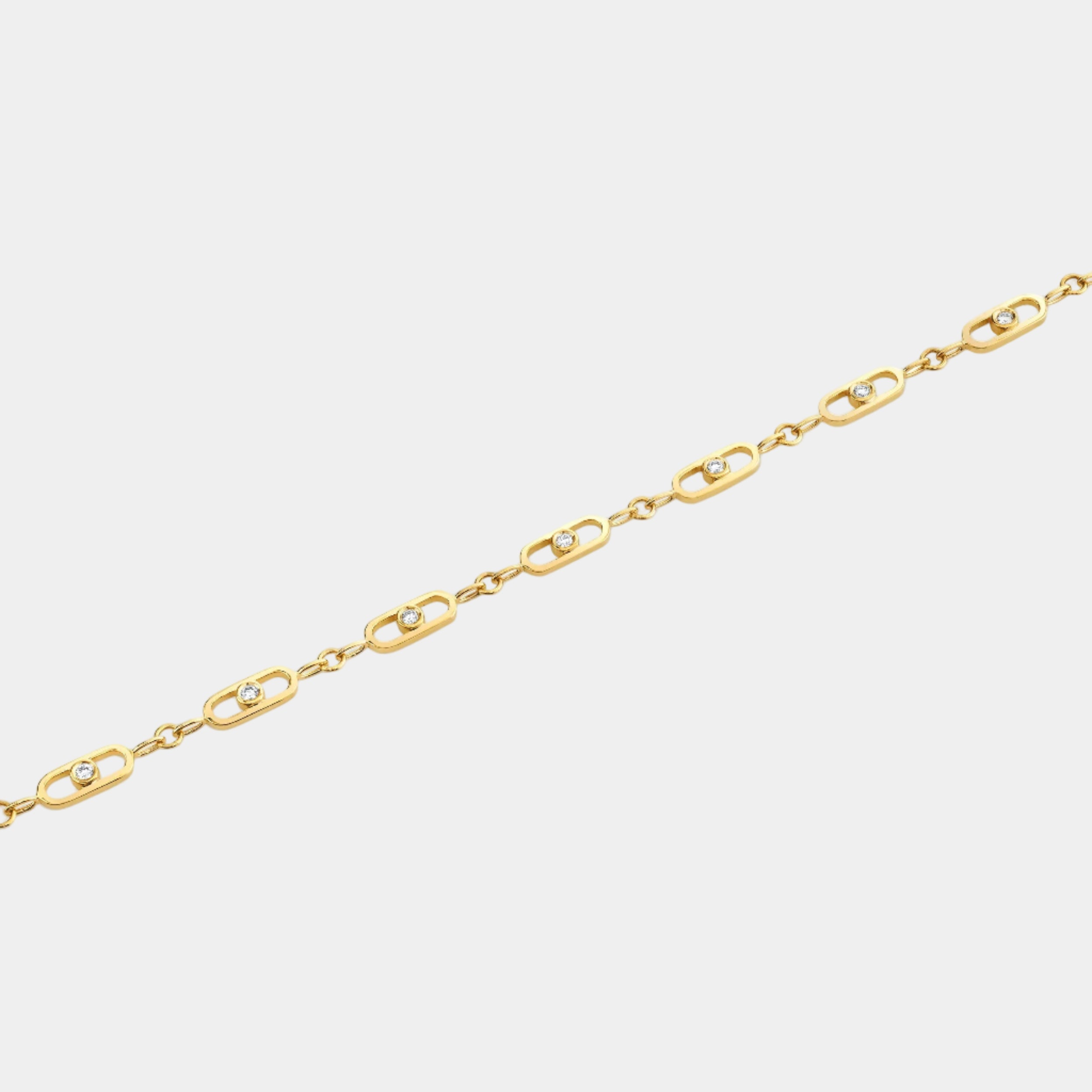 Yellow gold paperclip link bracelet with bezel set diamonds on grey background
