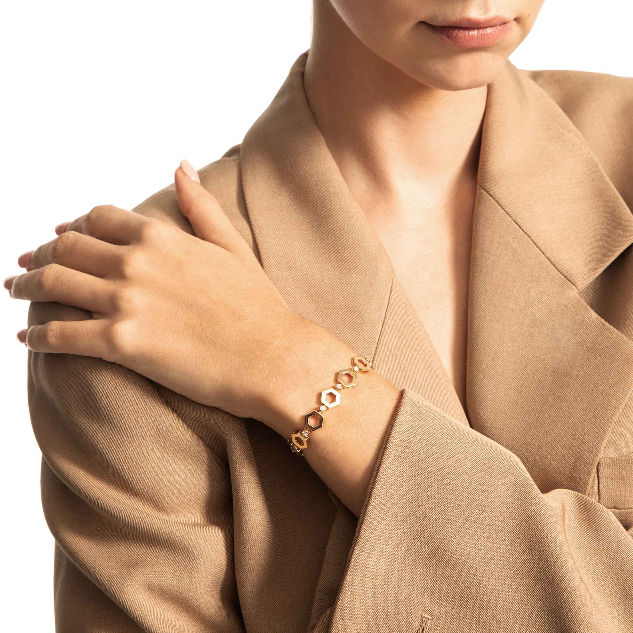 Woman wearing yellow gold hexagon shaped diamond link bracelet