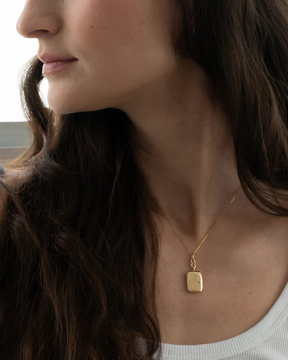 Woman wears Yellow gold locket necklace