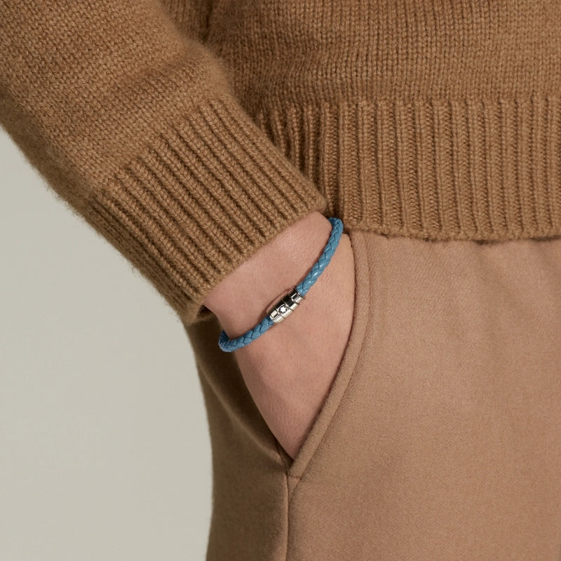 Man wearing Montblanc smoky blue braided leather bracelet with polished stainless steel clasp featuring the Montblanc emblem
