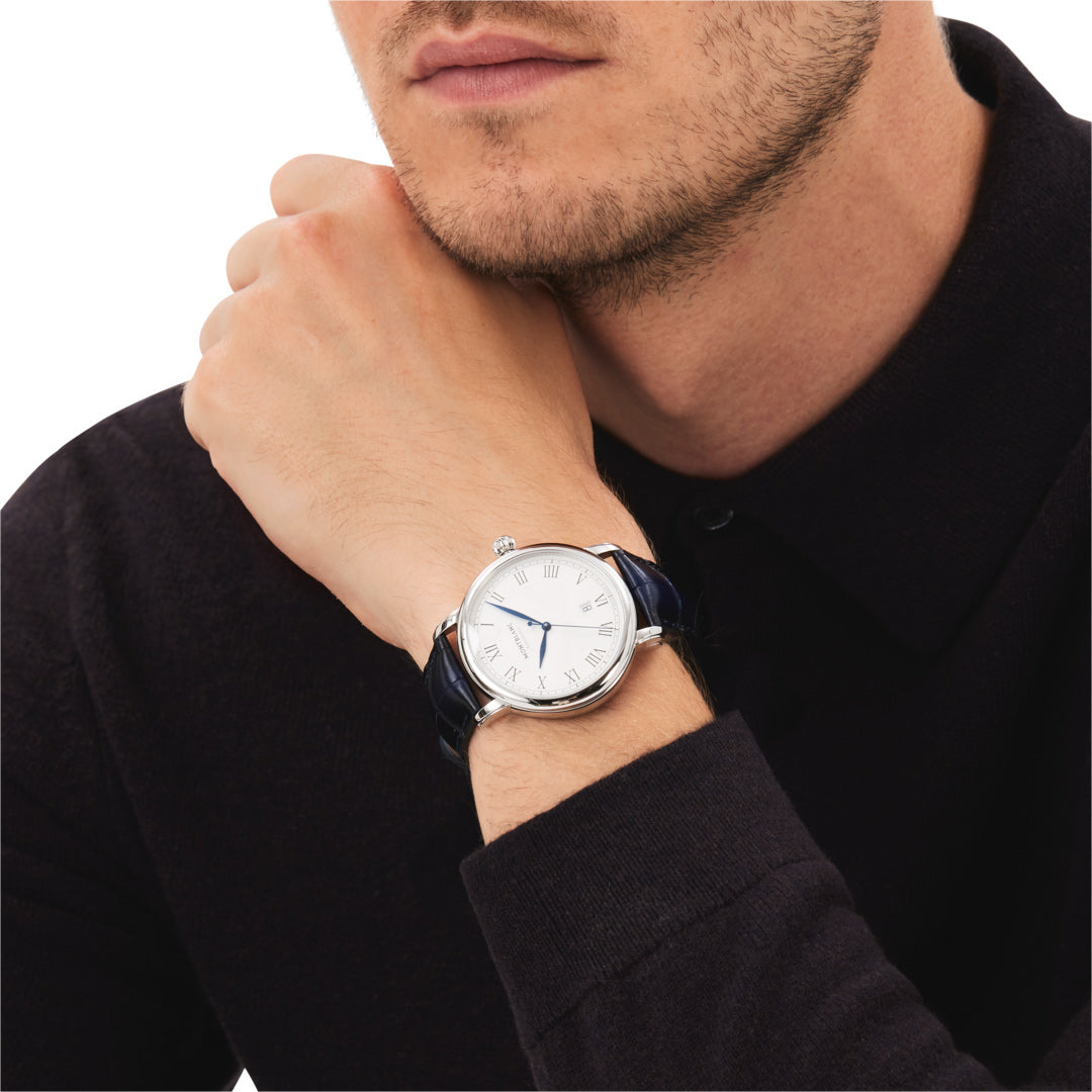Man wearing a watch with a white face and blue strap on a plain background