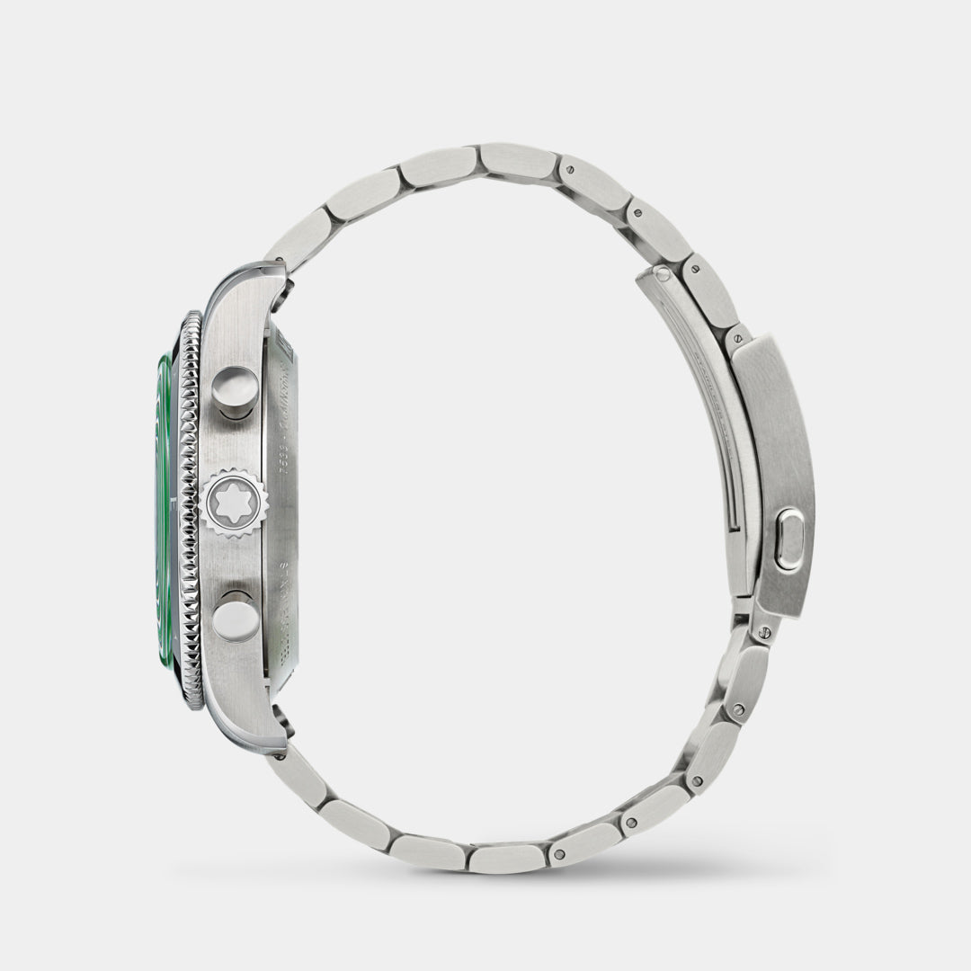 Close-up of a silver watch with a green face on a white background