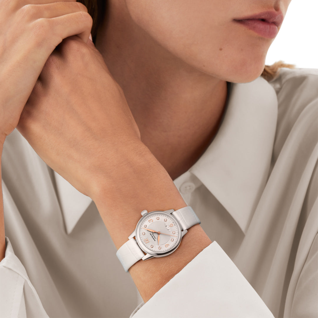 Close-up of a person wearing a white watch with a light background