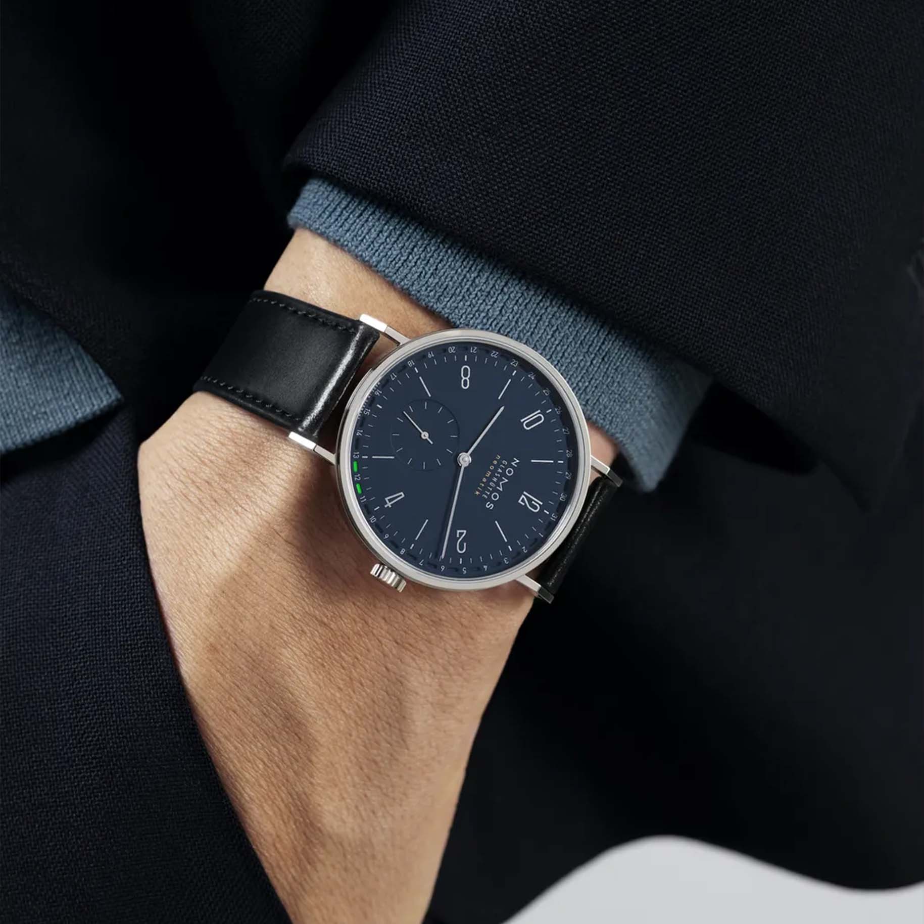 Man wearing NOMOS Glashütte Tangente Neomatik 41mm watch with midnight blue dial, stainless steel case, and black leather strap