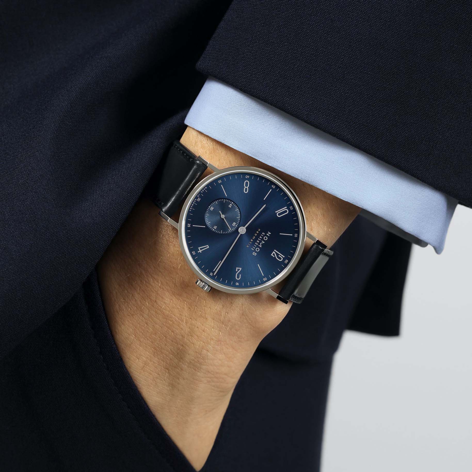 Man wearing NOMOS Glashütte Tangente Neomatik Blue Gold 39mm automatic watch with blue sunburst dial, stainless steel case, and black leather strap.