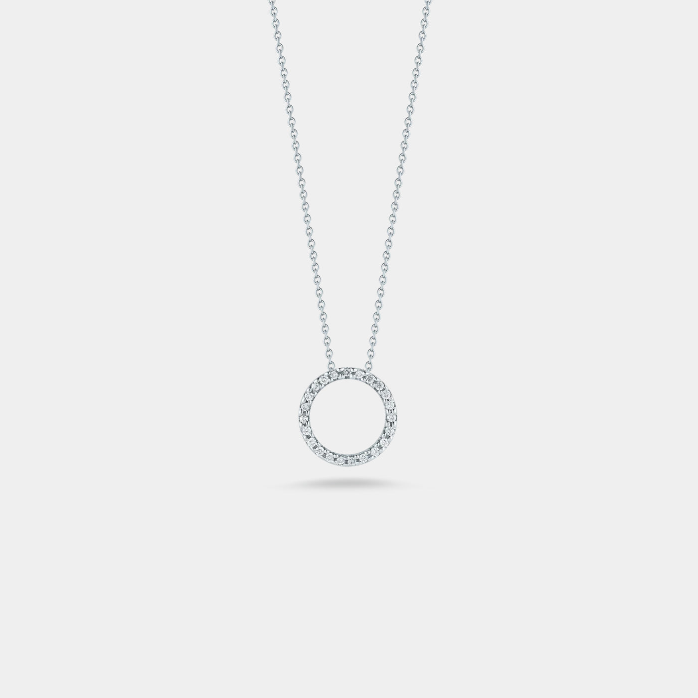 White gold diamond circle pendant necklace on gray background.