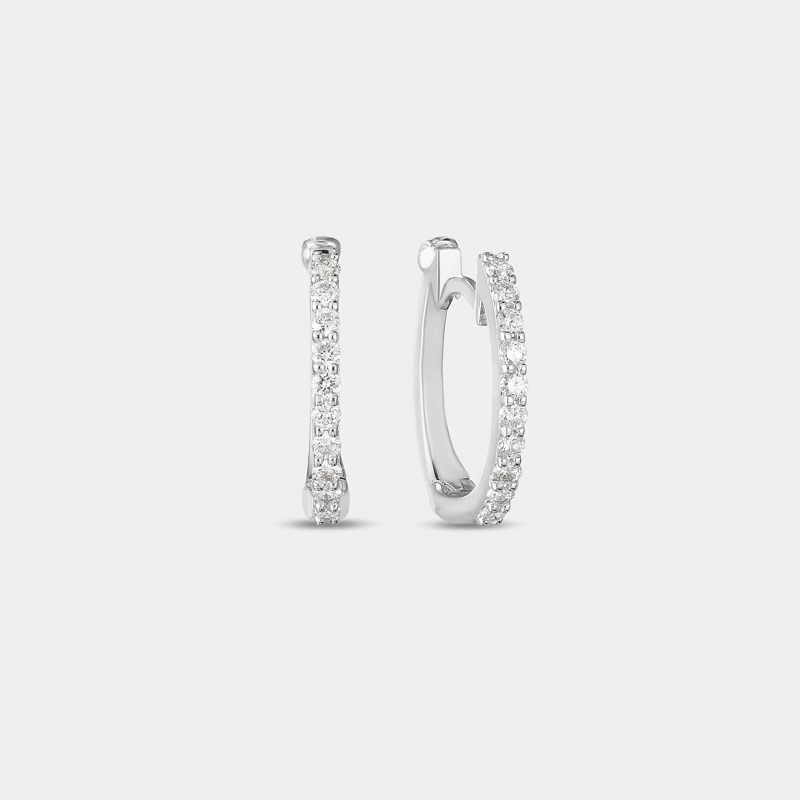 White gold diamond huggie earrings on gray background