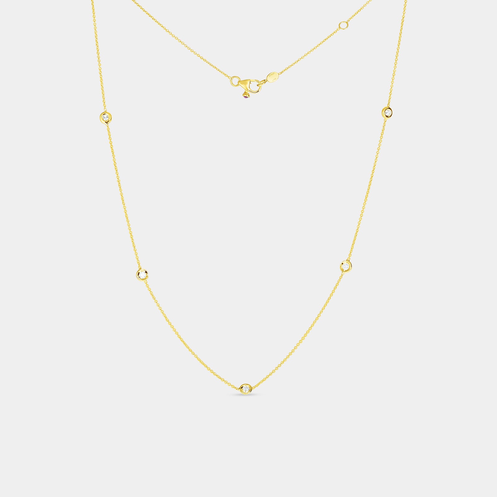 Yellow gold 5 station diamond necklace on gray background.