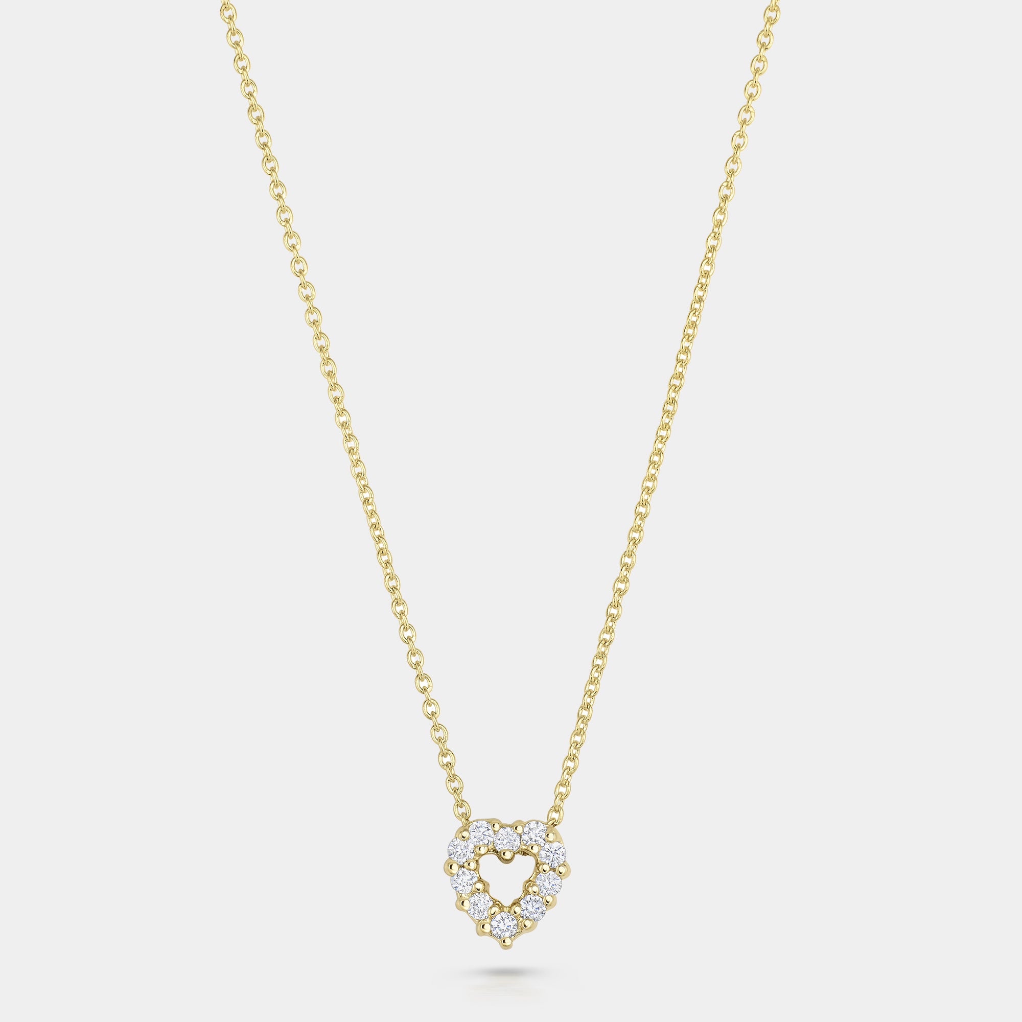 Yellow gold diamond heart pendant necklace on gray background
