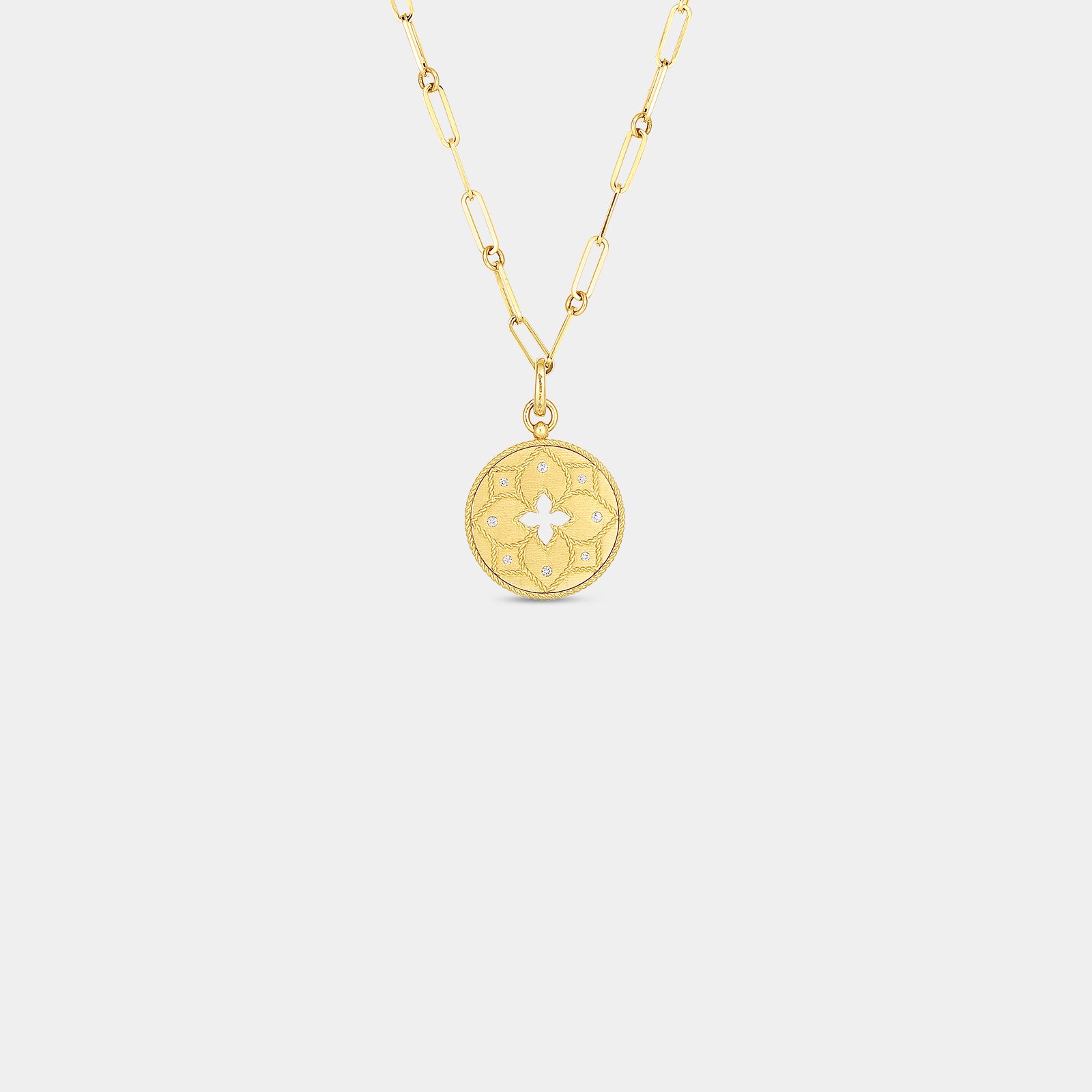 Yellow gold diamond pendant necklace with floral center cut out on gray background
