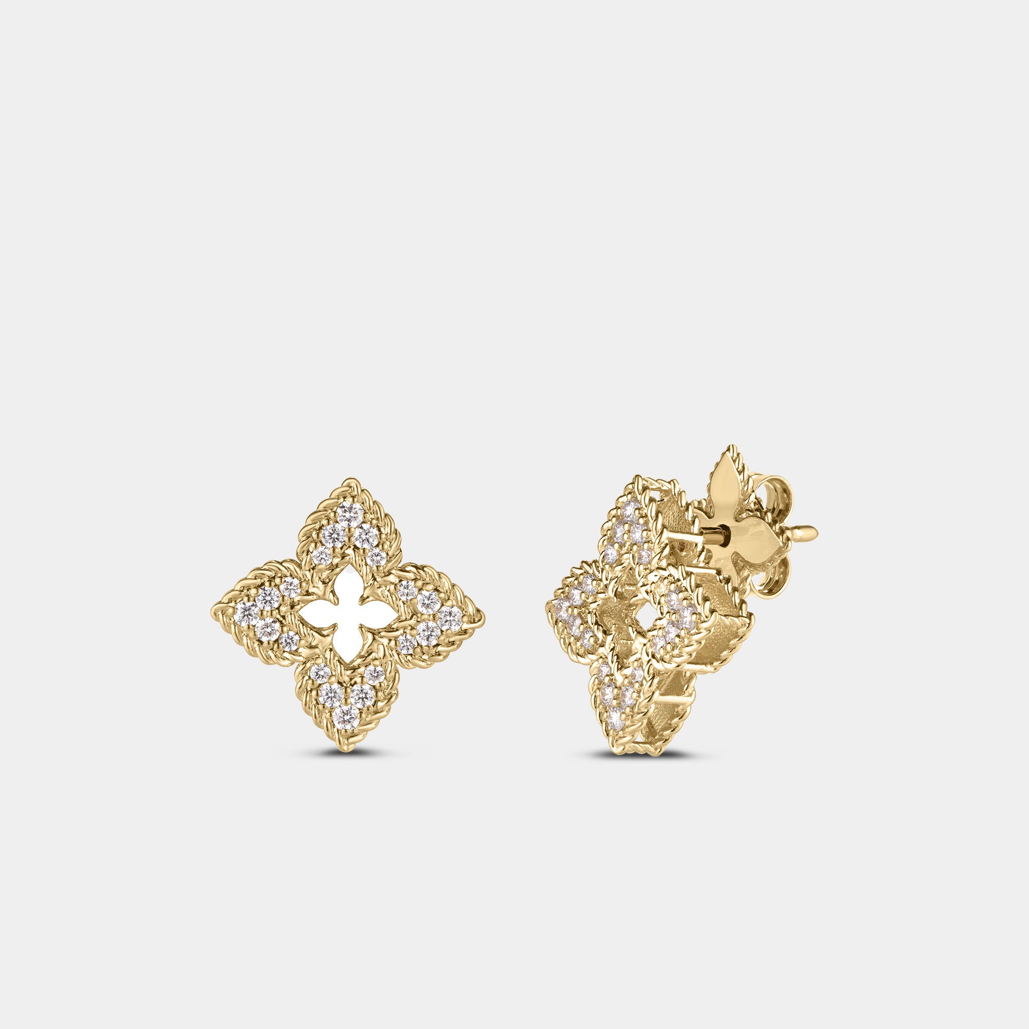 Yellow gold diamond floral stud earrings on gray background.