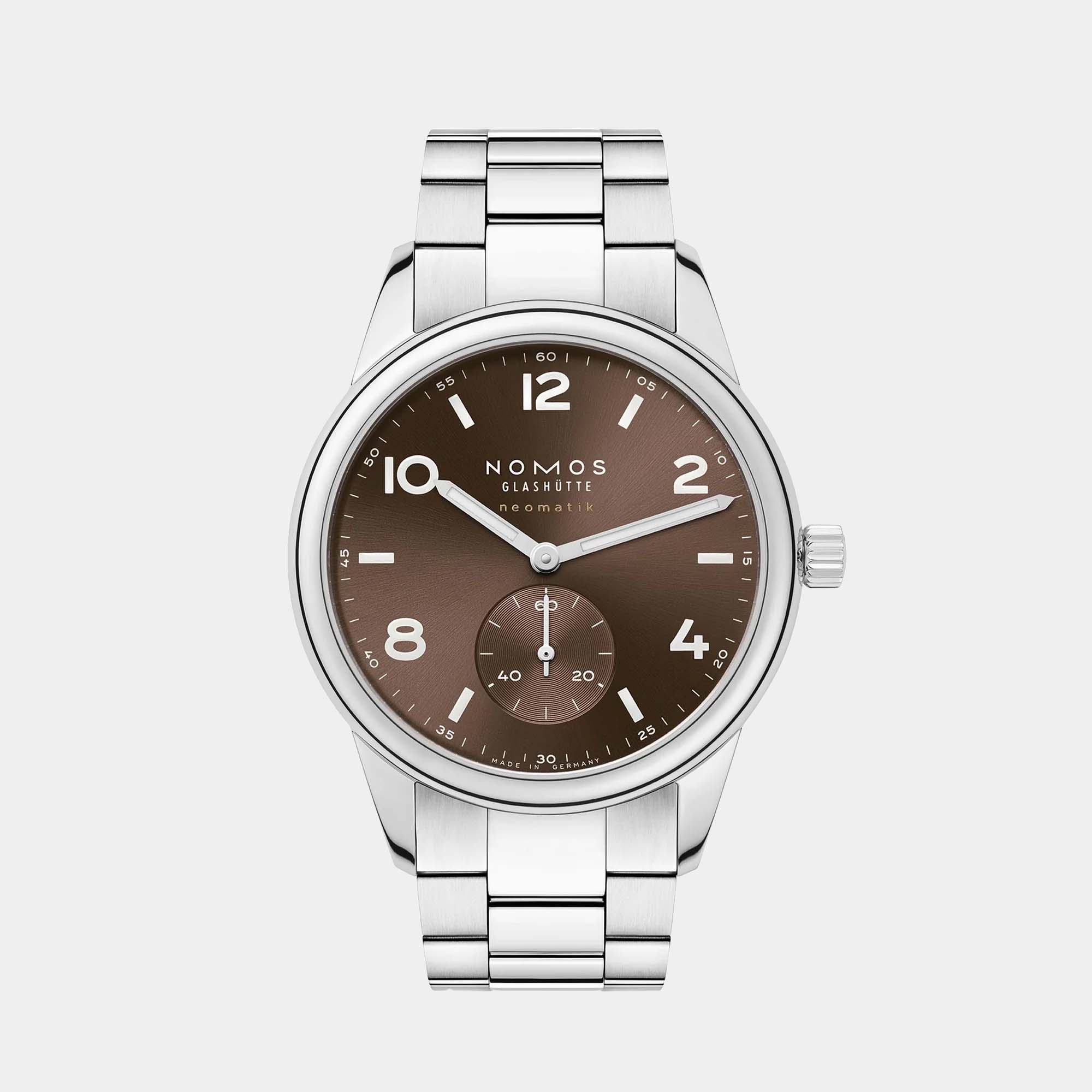 NOMOS Glashütte Club Sport Neomatik 39mm watch with tabac brown sunburst dial, luminous hands, and stainless steel bracelet on grey background.