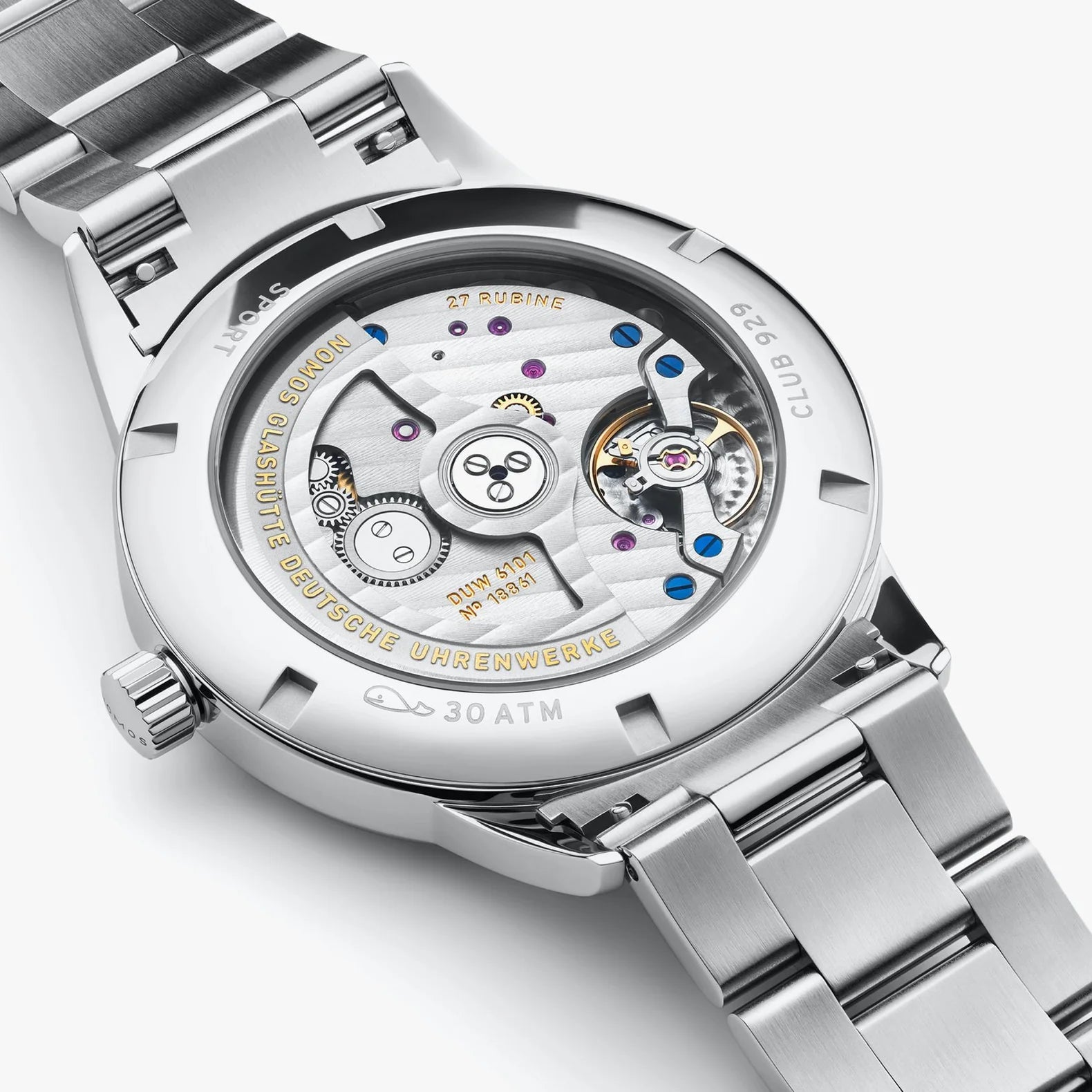 NOMOS Glashütte Club Sport Neomatik 42mm watch with black dial, luminous hands, and stainless steel bracelet on grey background, exhibition caseback view