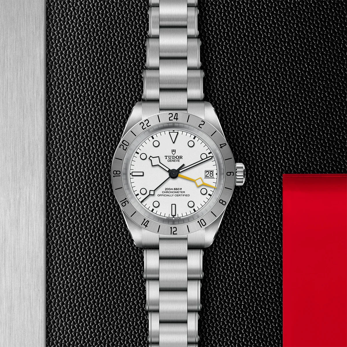 TUDOR black bay pro 39mm opaline dial watch on 3-link bracelet, displayed in a top-down flat-lay composition on Tudor’s signature textured backdrop.