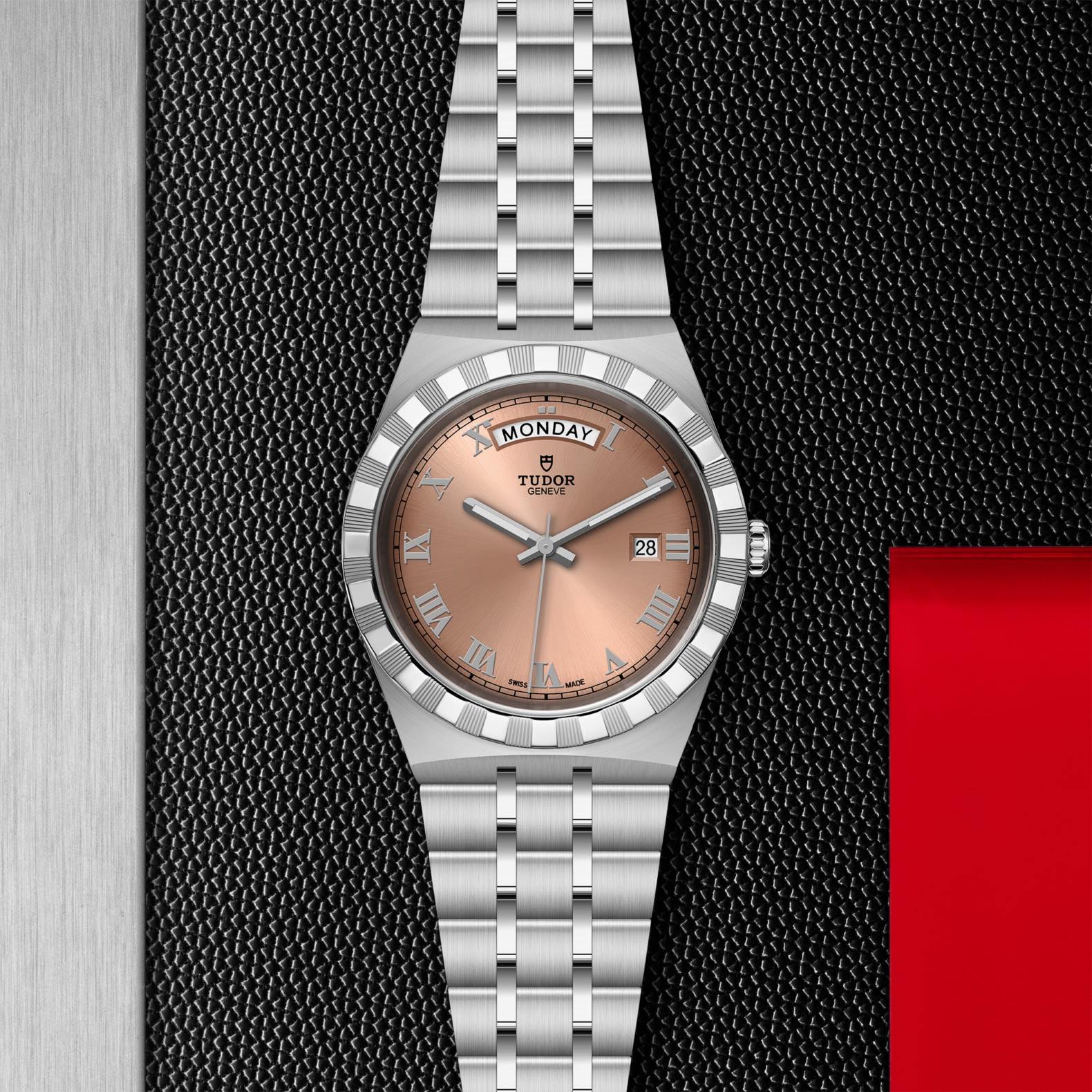 TUDOR tudor royal 41mm salmon dial watch, displayed in a top-down flat-lay composition on Tudor’s signature textured backdrop.