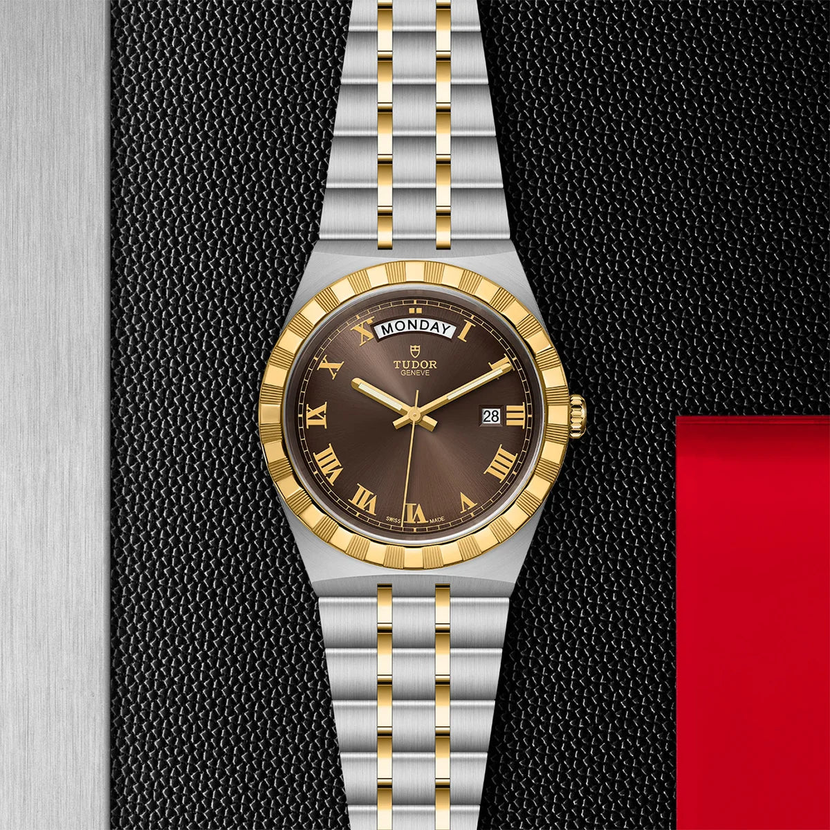 TUDOR tudor royal two-tone 41mm brown dial watch, displayed in a top-down flat-lay composition on Tudor’s signature textured backdrop.