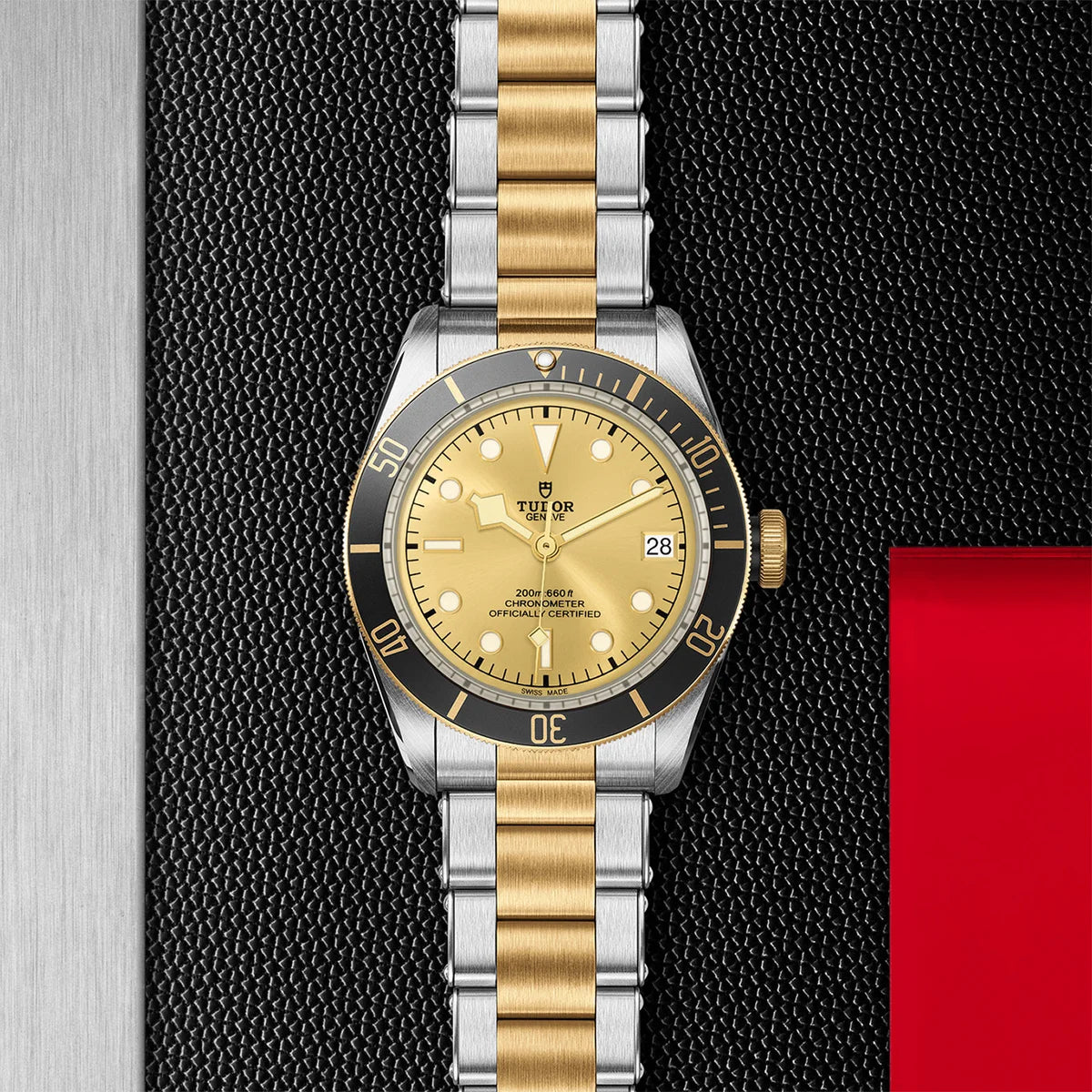 TUDOR black bay s&g 41mm gold dial watch on 3-link bracelet, displayed in a top-down flat-lay composition on Tudor’s signature textured backdrop.