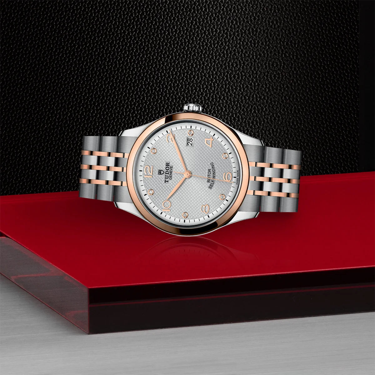 TUDOR 1926 two-tone 39mm silver diamond dial watch on bracelet, shown laying on its side on Tudor’s signature red platform.