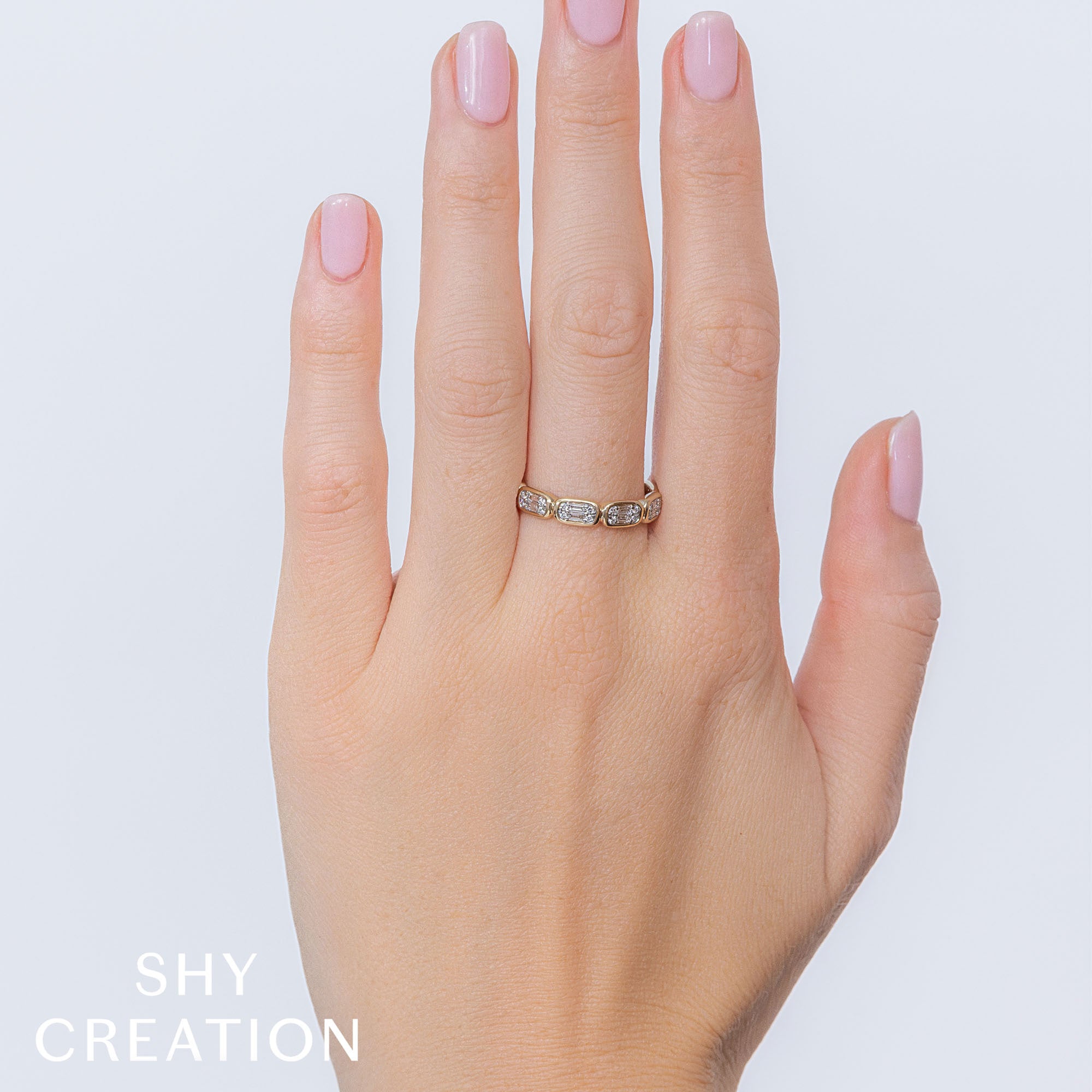 Woman's hand wearing yellow gold baguette diamond fashion ring