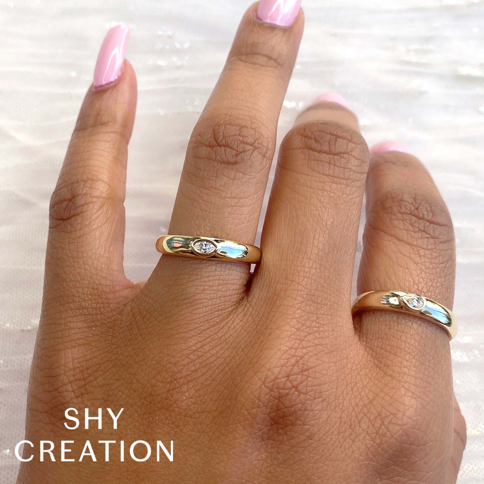 Woman's hand wearing yellow gold bezel set marquise diamond fashion ring