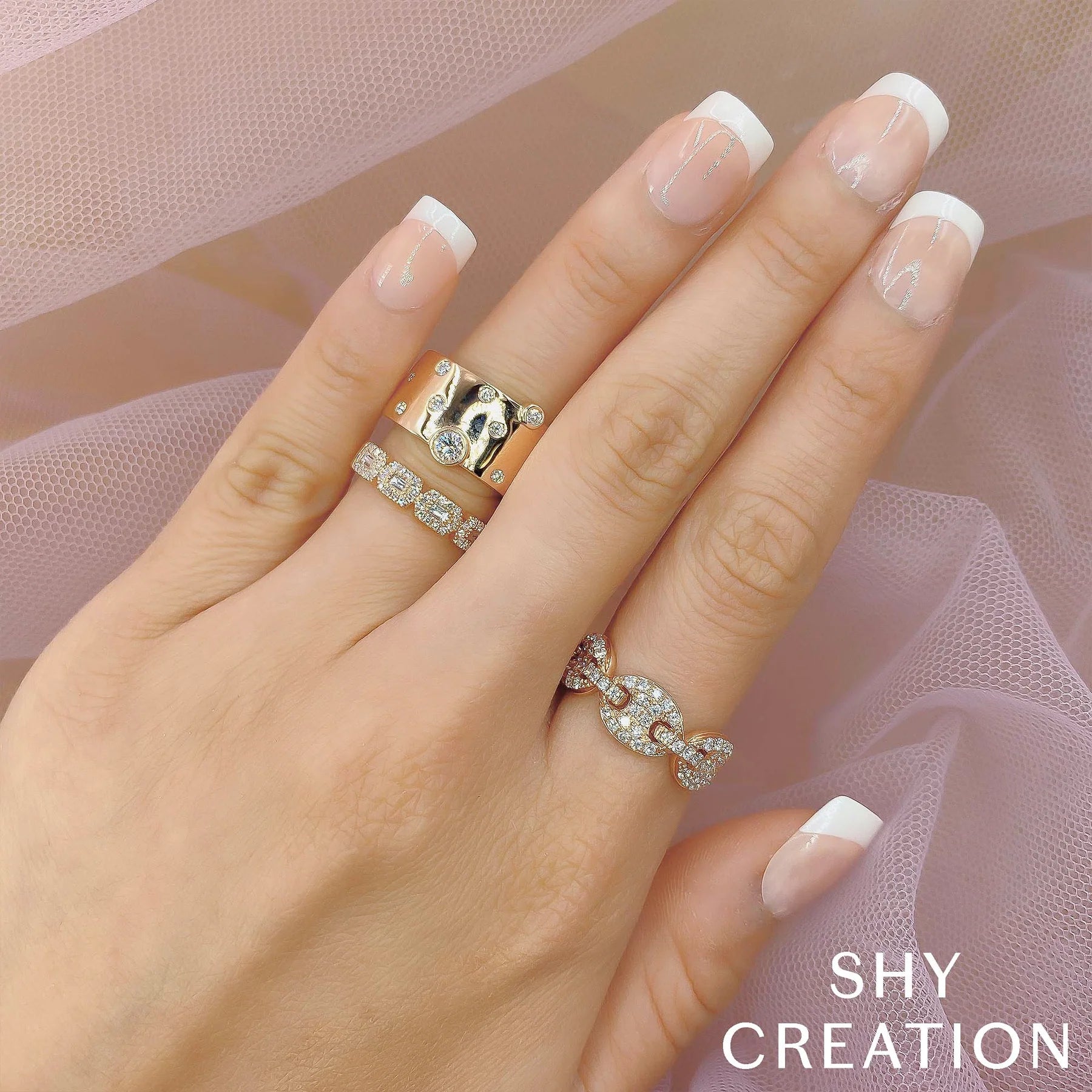 Woman's hand wearing yellow gold bezel set diamond fashion ring with scattered diamond design