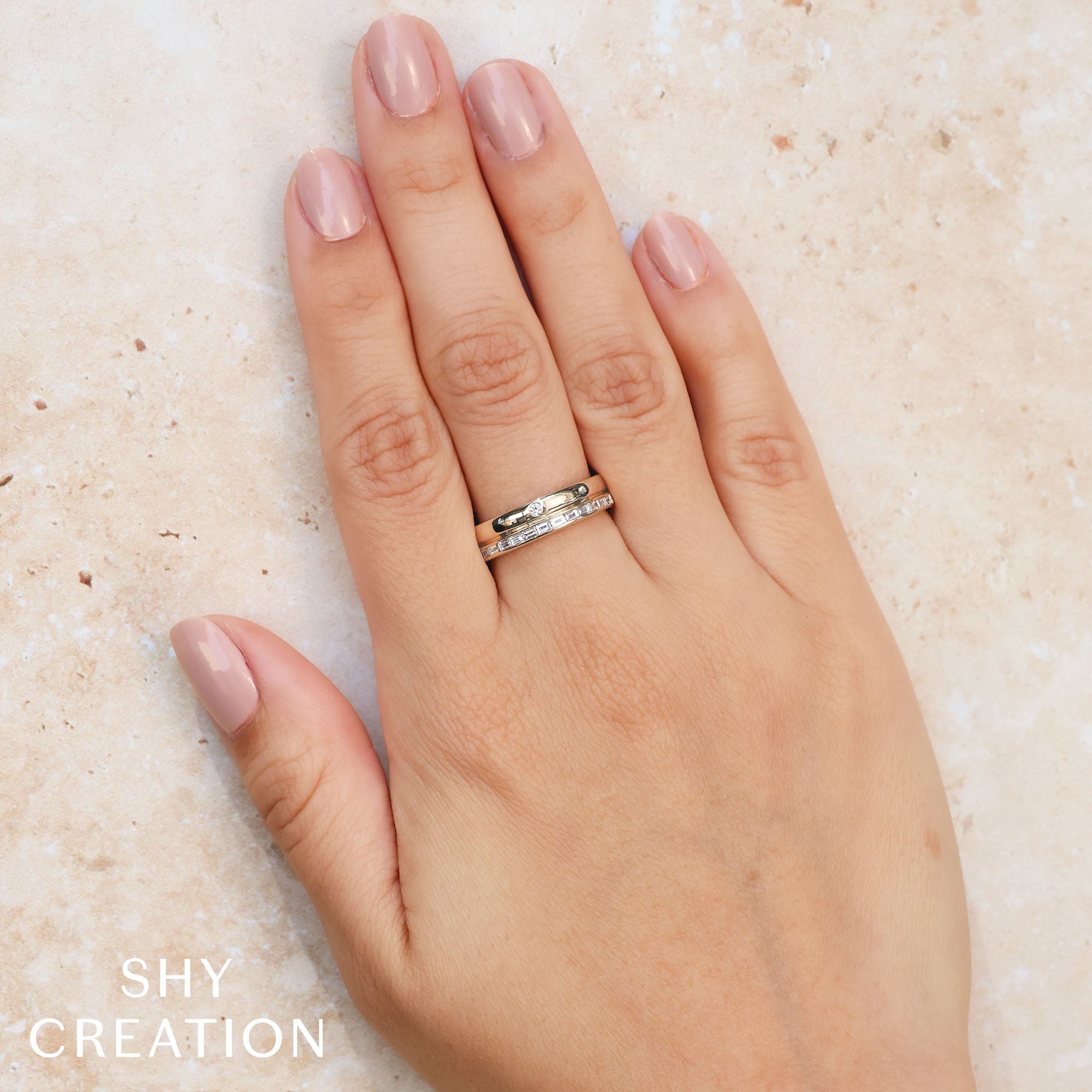 Woman's hand wearing yellow gold channel set baguette diamond fashion ring