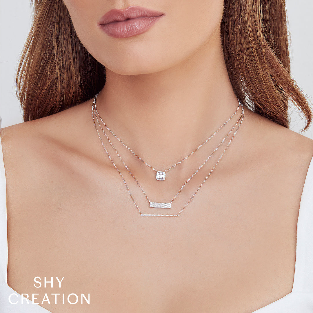 Necklace with square pendant on a plain background, featuring 'SHY CREATION' branding.