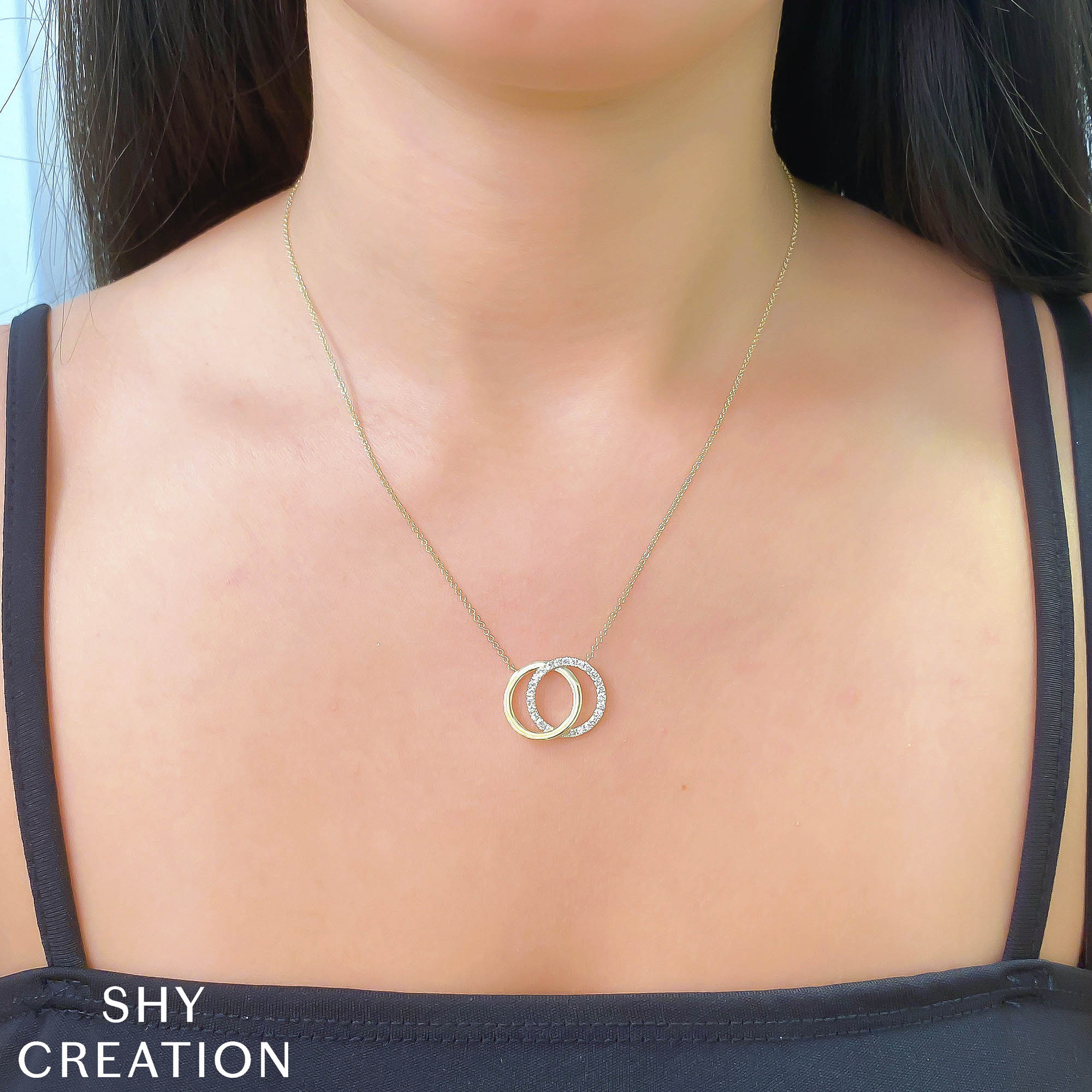 Woman wearing yellow gold and diamond interlocking circle pendant necklace