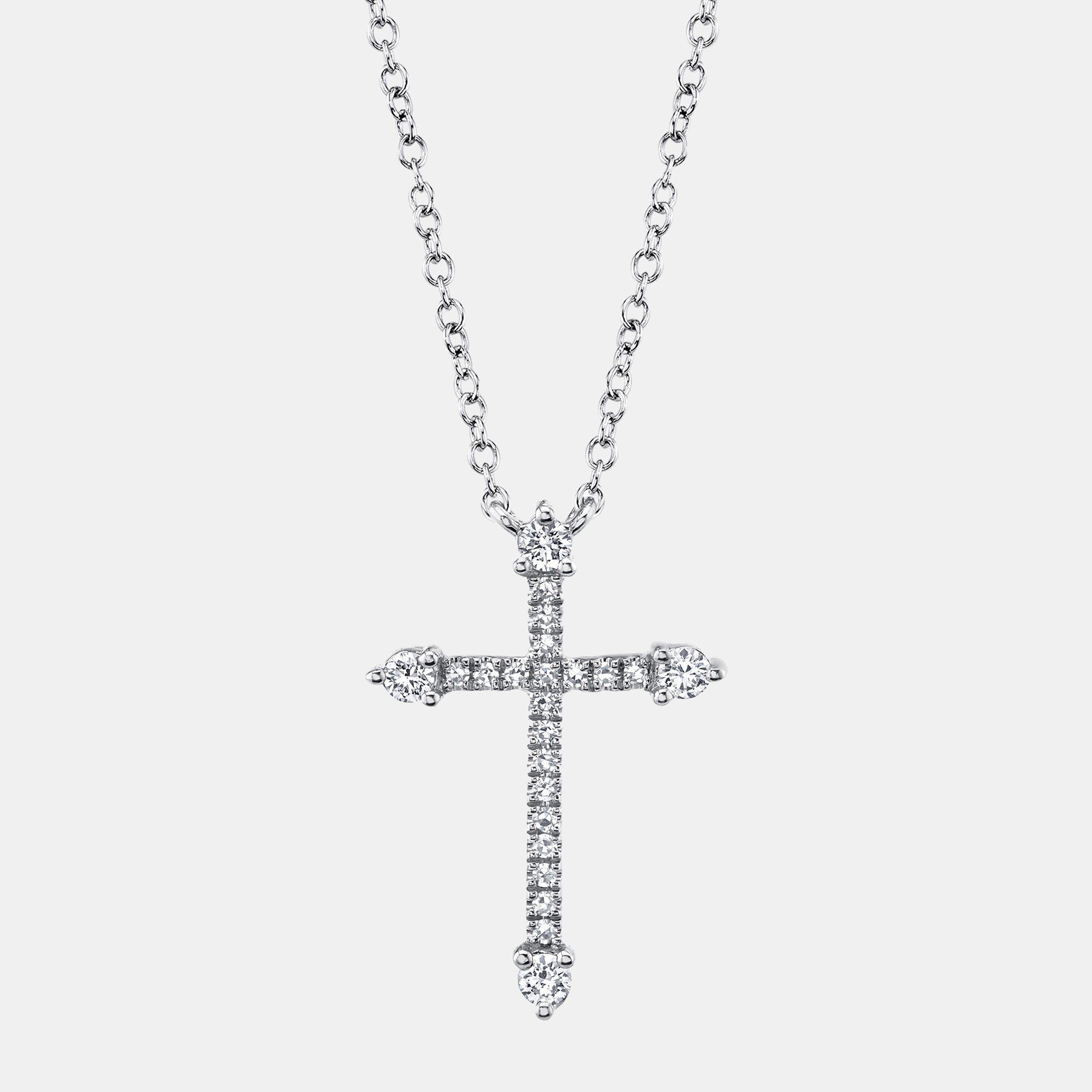 White gold cross necklace with diamonds on a light gray background