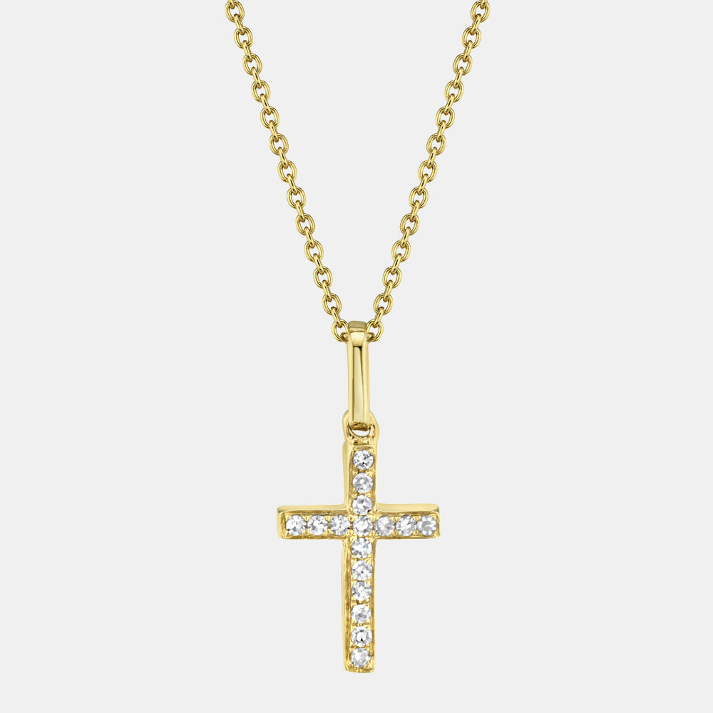 Gold cross necklace with diamonds on a light gray background