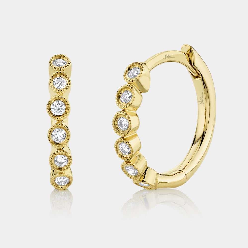 Yellow gold diamond huggie earrings, front angle view