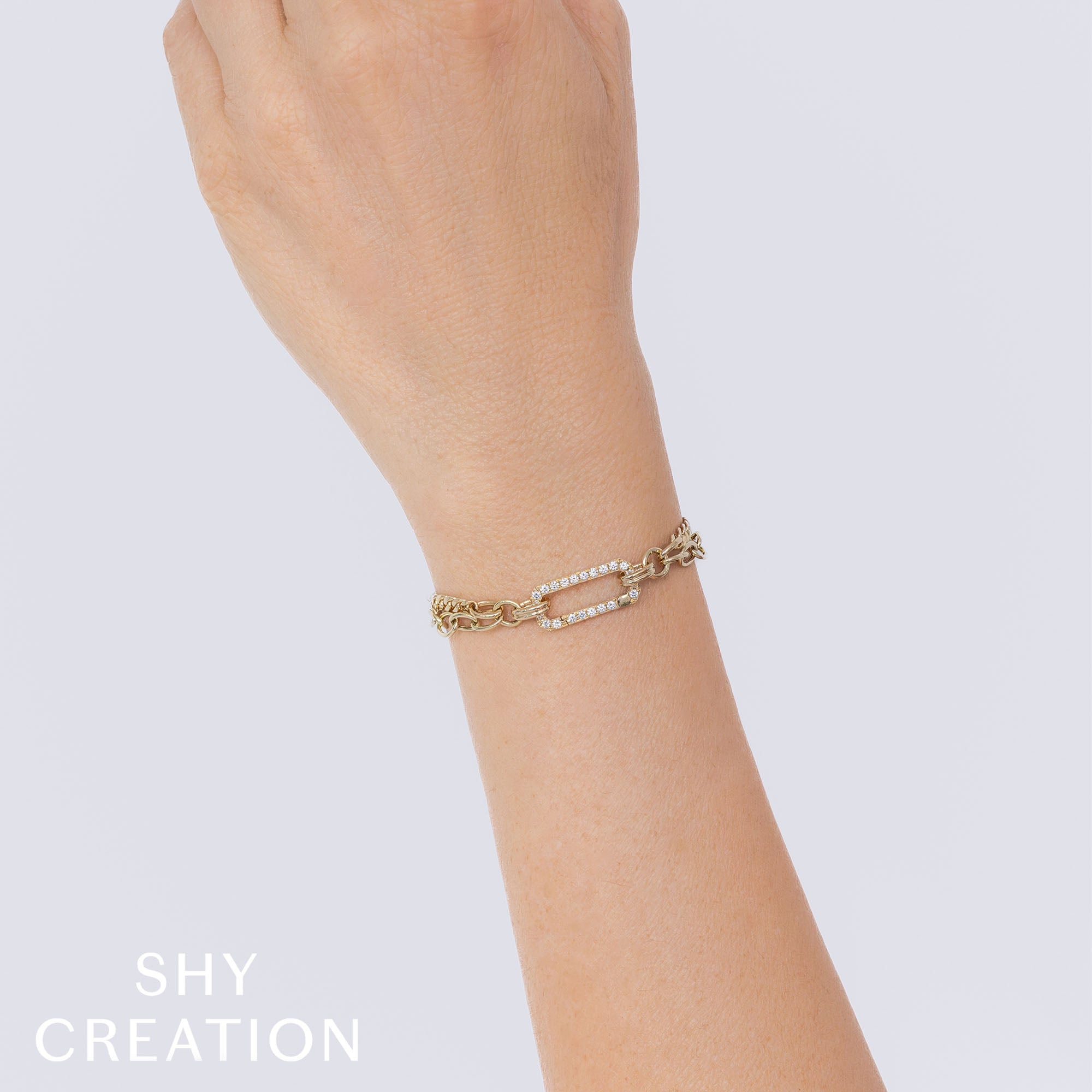 Woman wearing yellow gold double layer link diamond link bracelet, wrist closeup