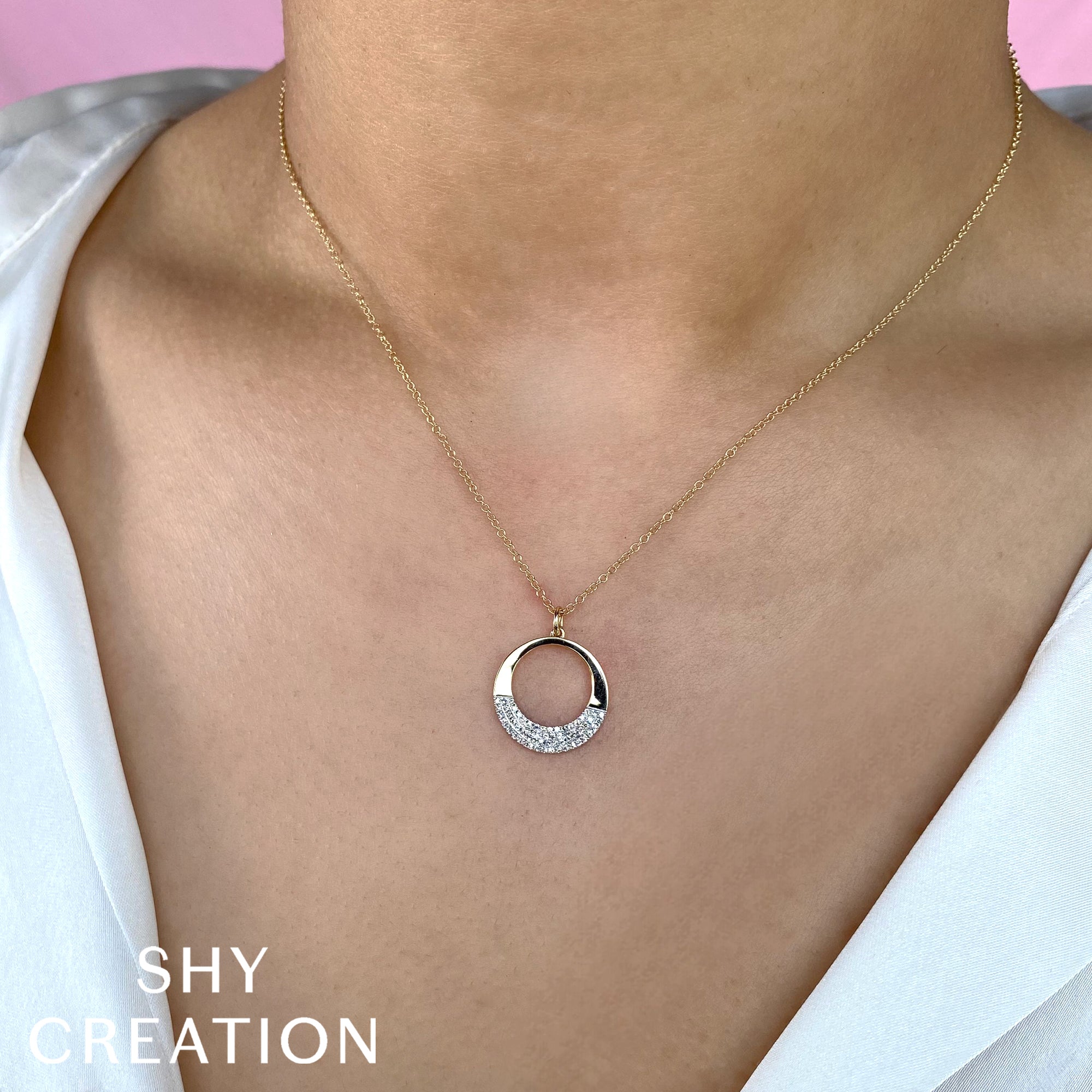 Woman wears yellow and white gold diamond circle necklace, front view