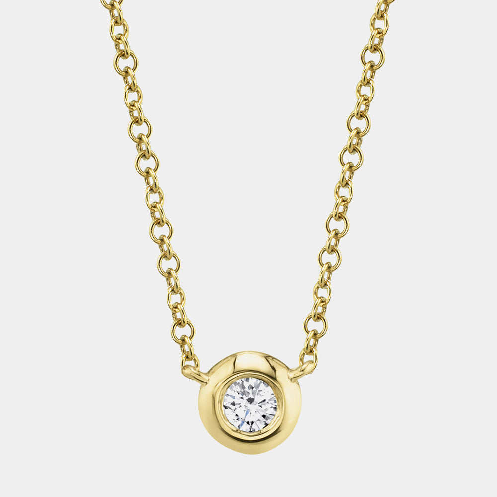 Gold necklace with a diamond pendant on a light gray background