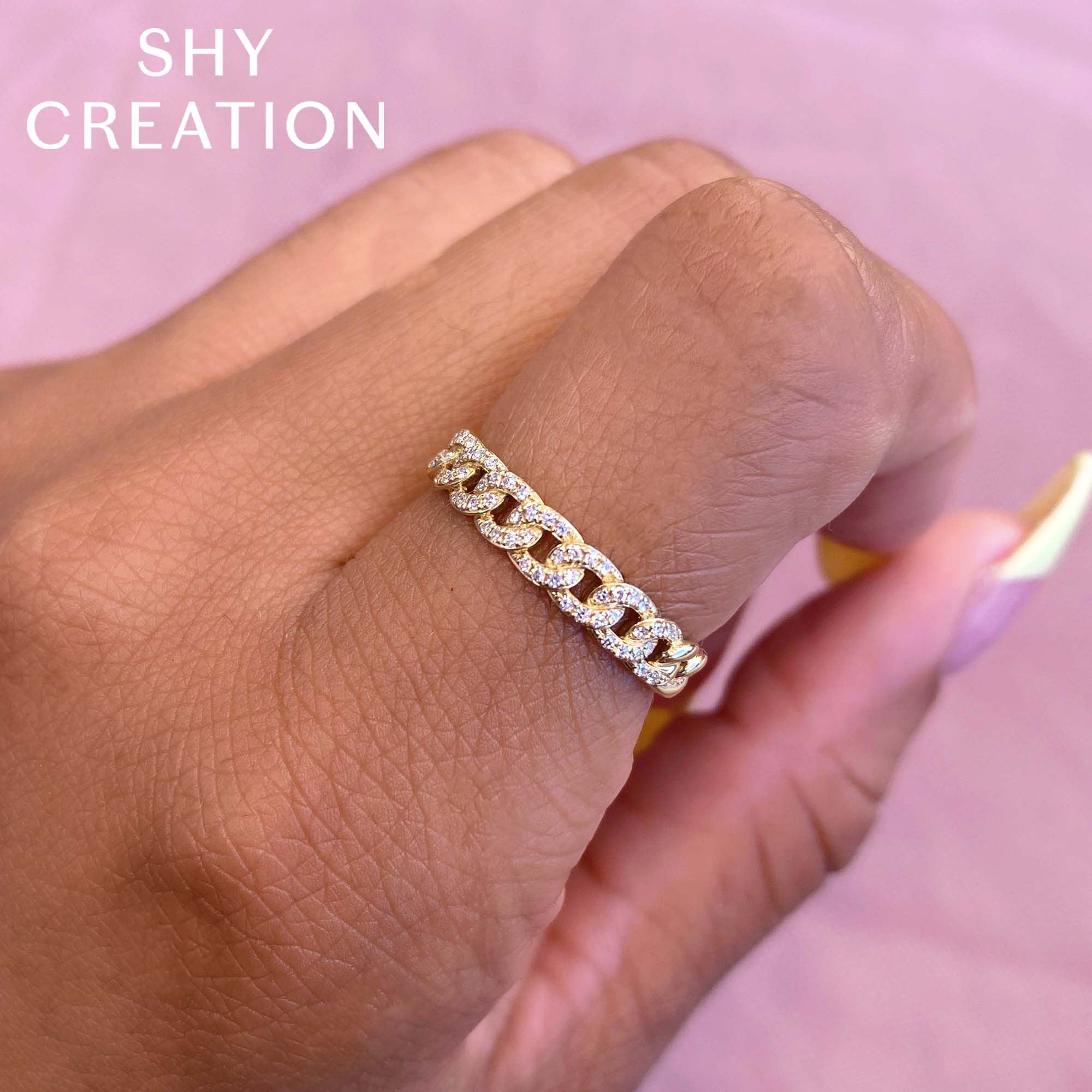 Woman's hand wearing yellow gold diamond link ring