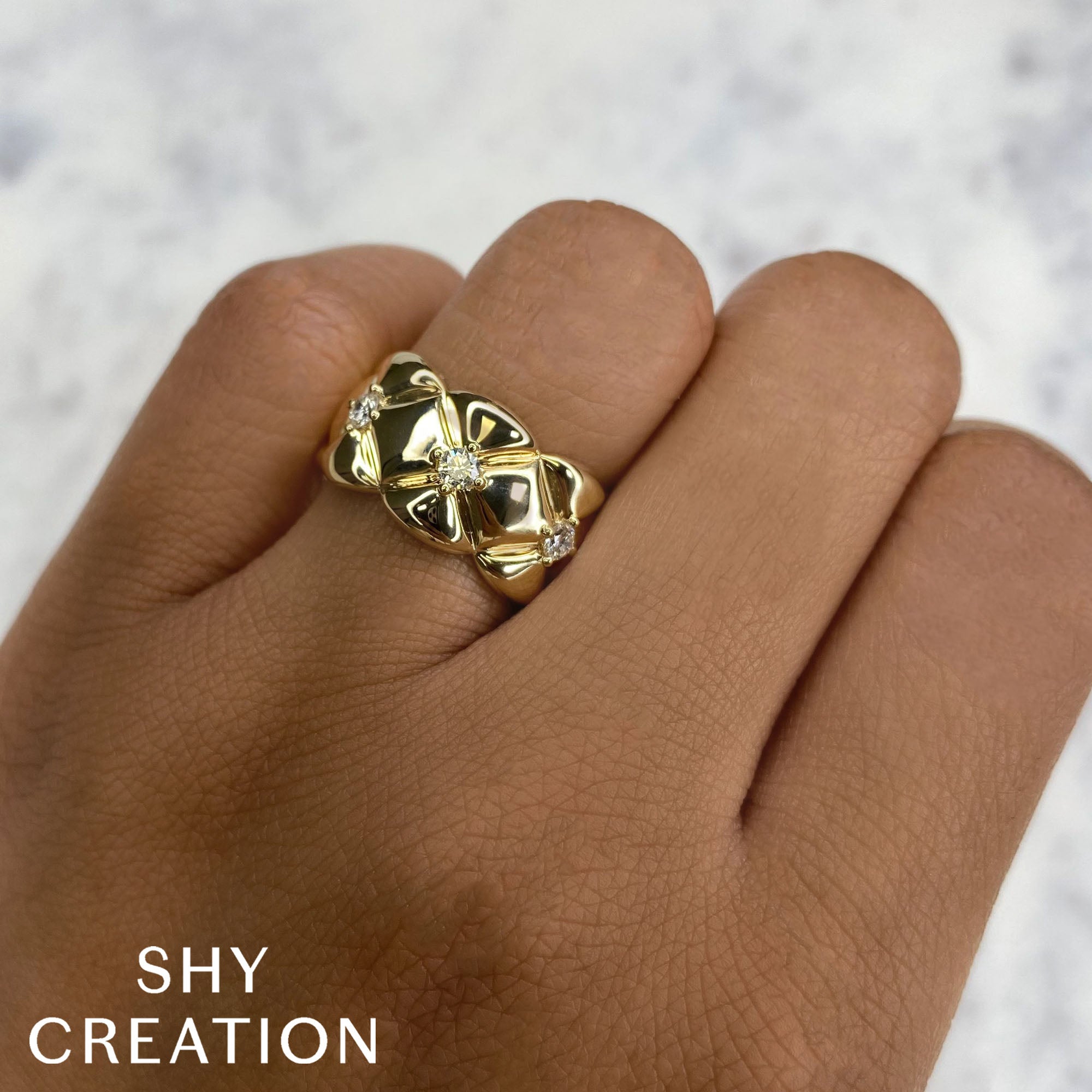 Woman's hand wearing yellow gold quilt design diamond fashion ring
