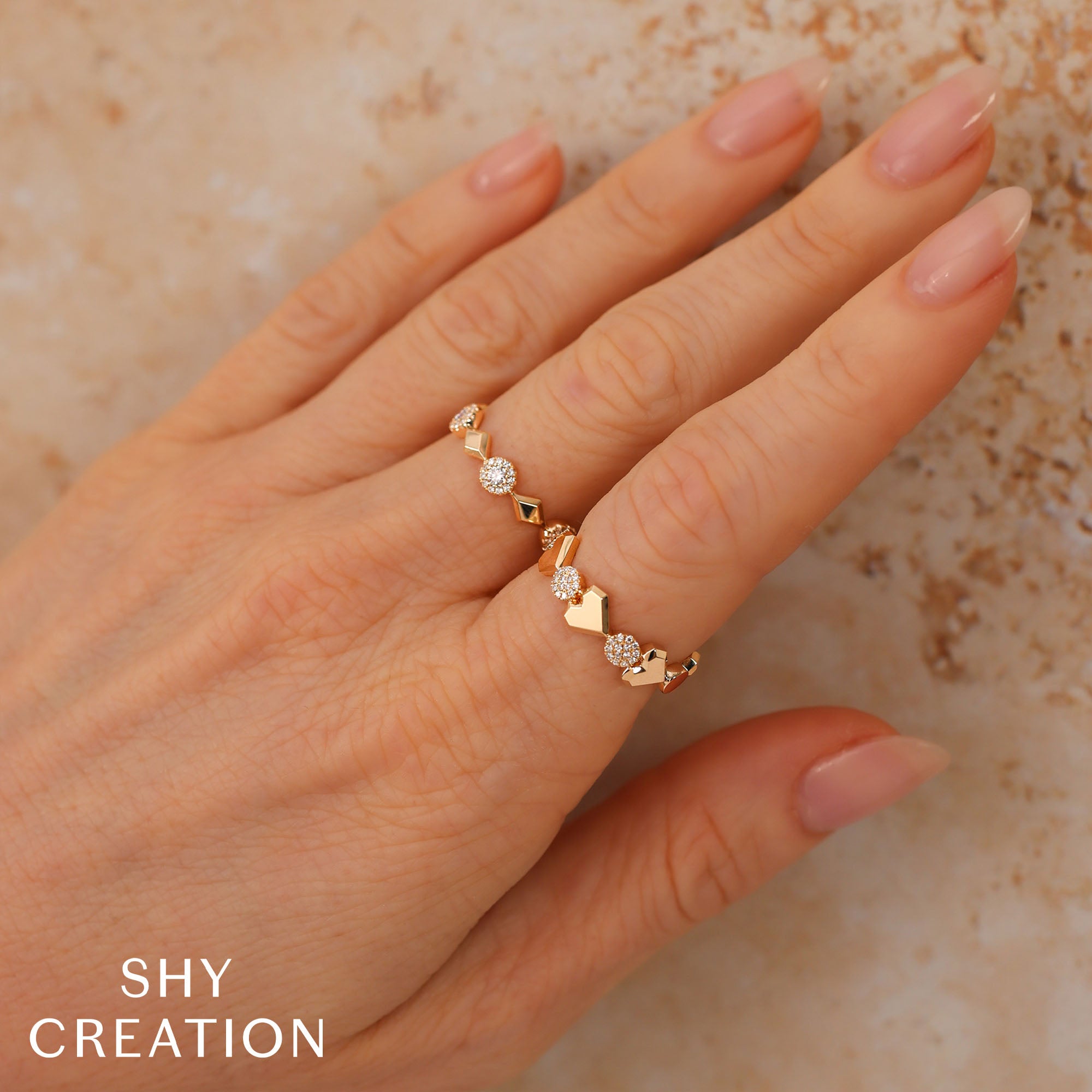 Woman's hand wearing yellow gold round geo cut diamond fashion ring