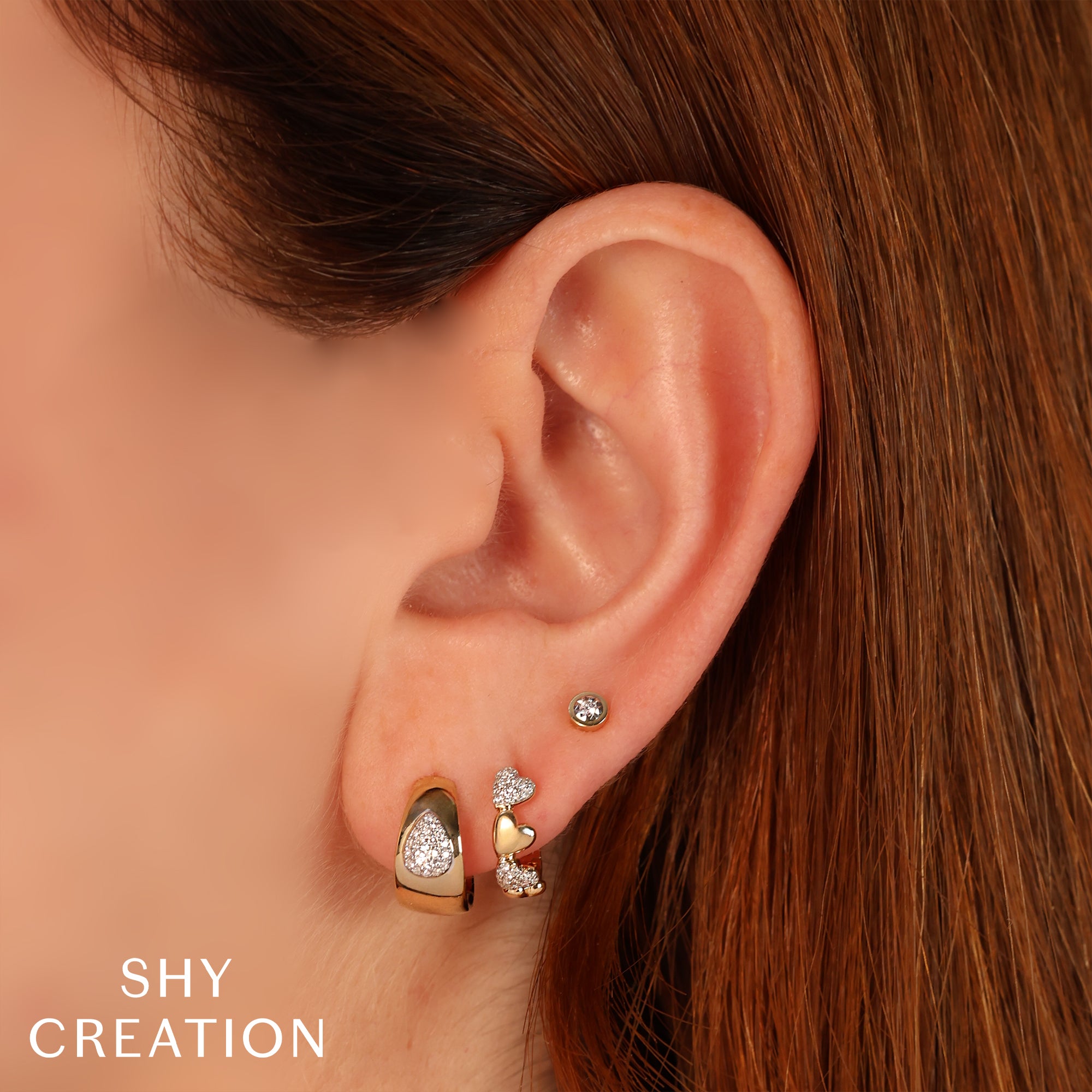 Woman wearing yellow gold bezel set diamond stud earrings