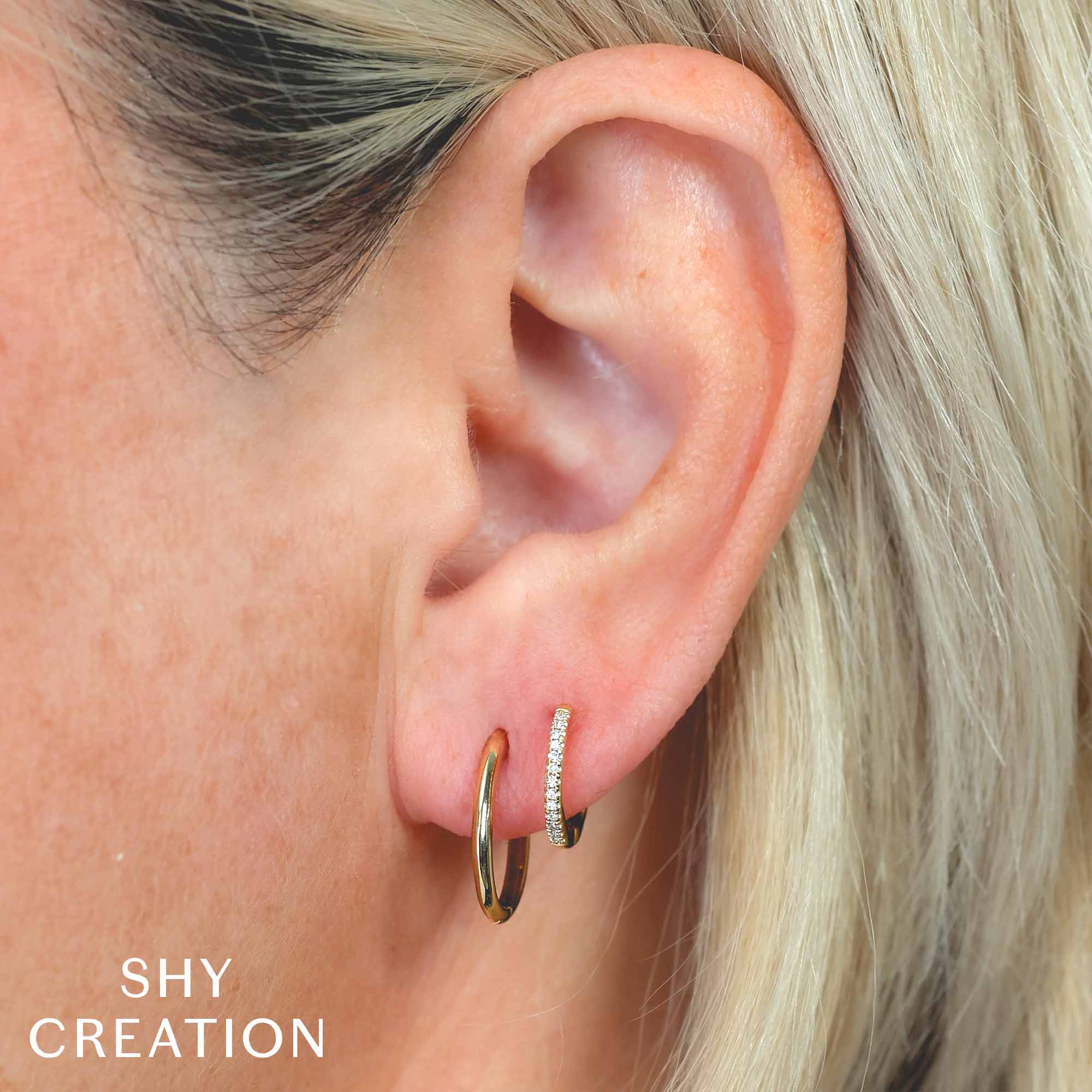 Woman wearing yellow gold diamond double huggie earring
