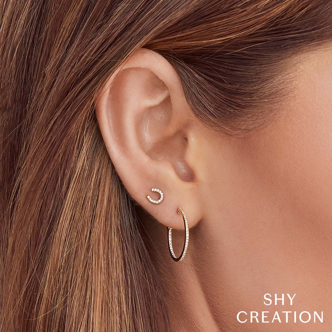 Woman wearing yellow gold diamond hoop earrings