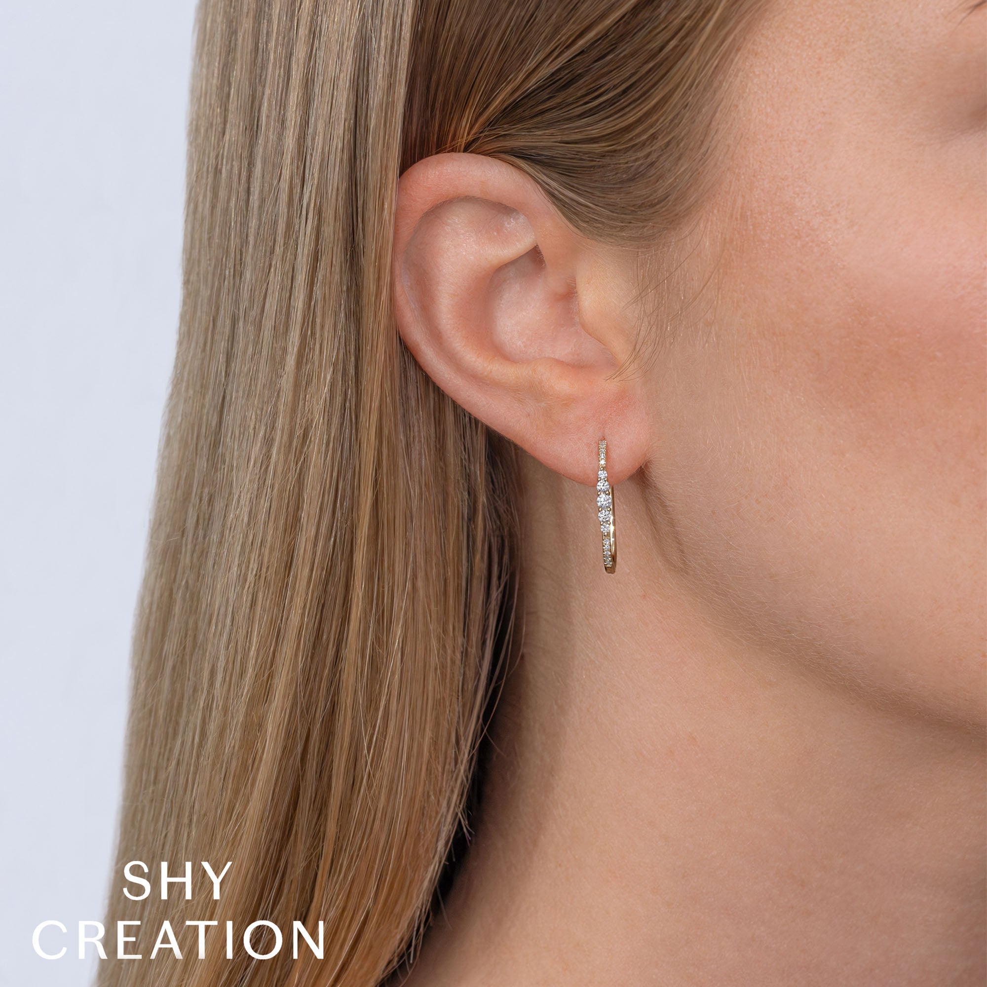 Woman wearing yellow gold diamond hoop earrings