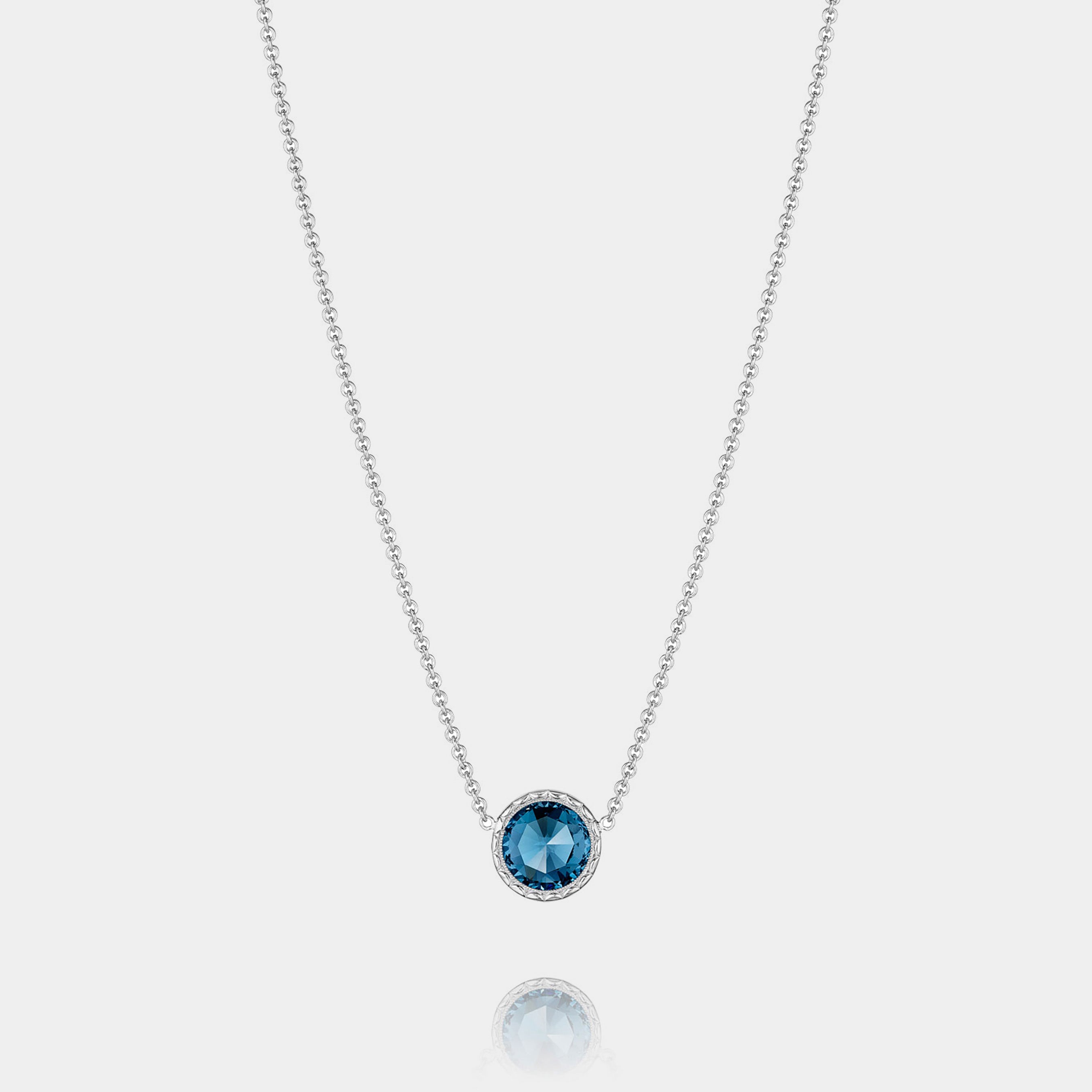 Sterling Silver and Yellow Gold London Blue Topaz Pendant Necklace on grey background.