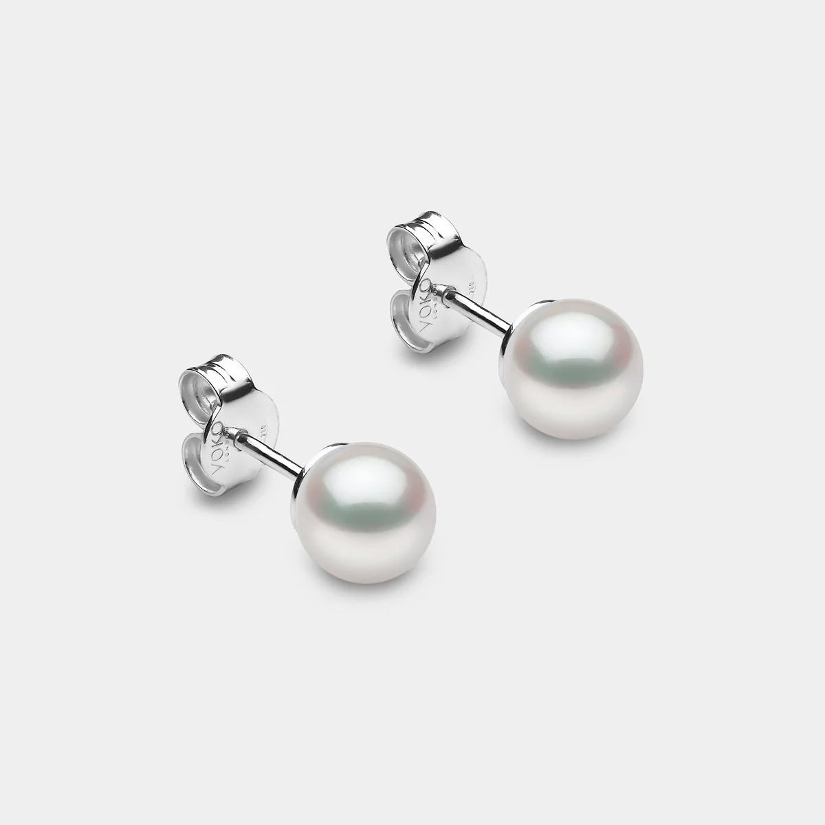 Pair of pearl stud earrings on a light gray background