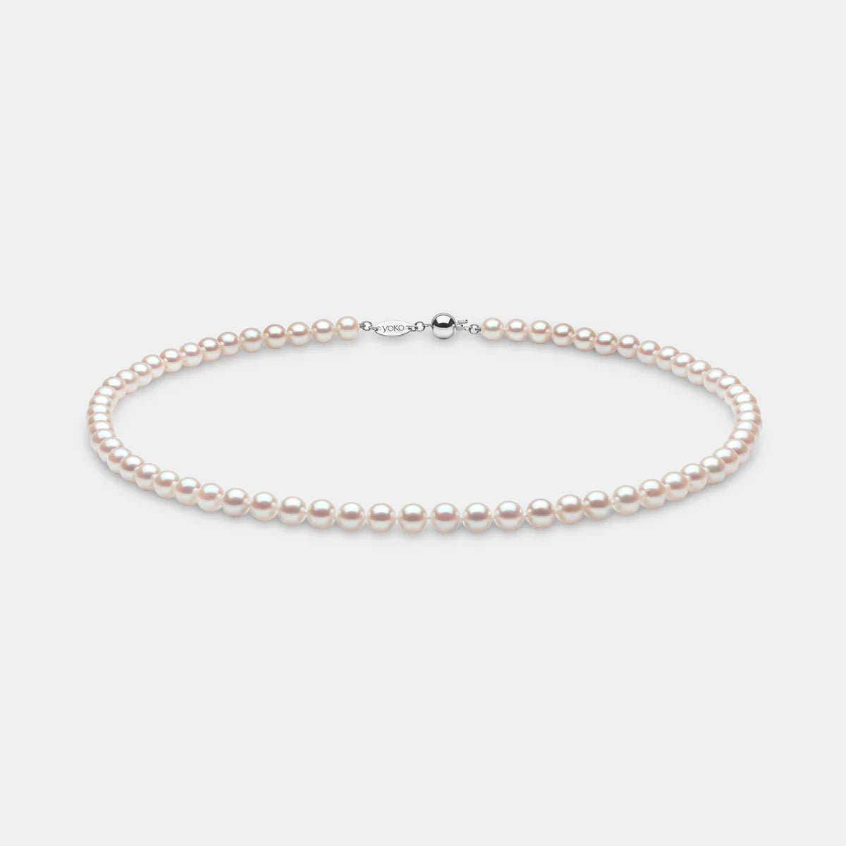 Pearl necklace on a light gray background