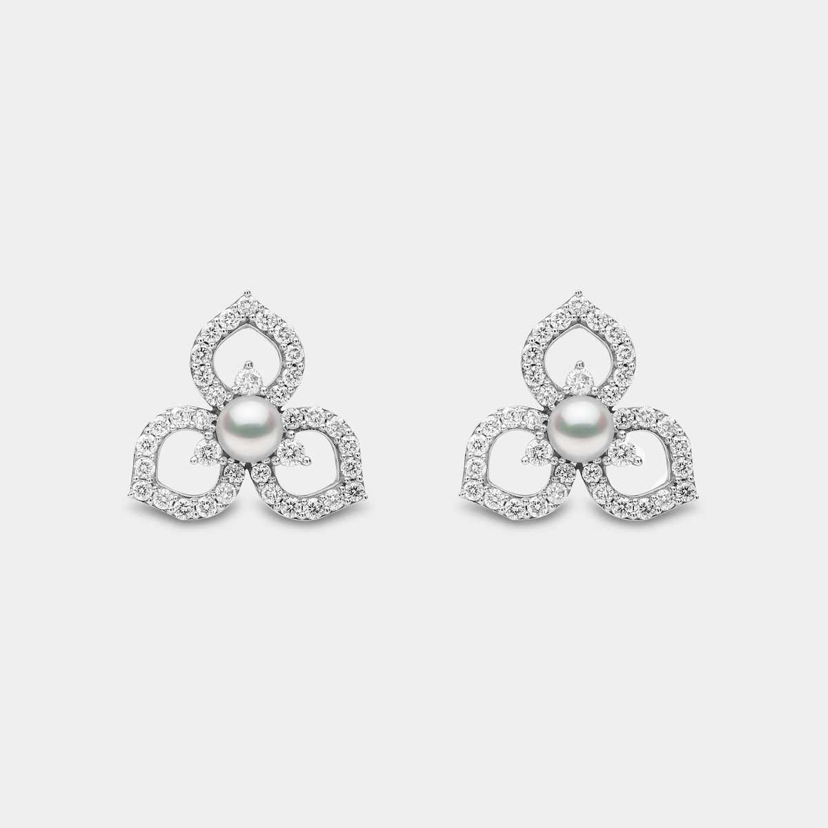 White gold pearl and diamond floral pattern stud earrings on grey background, front view