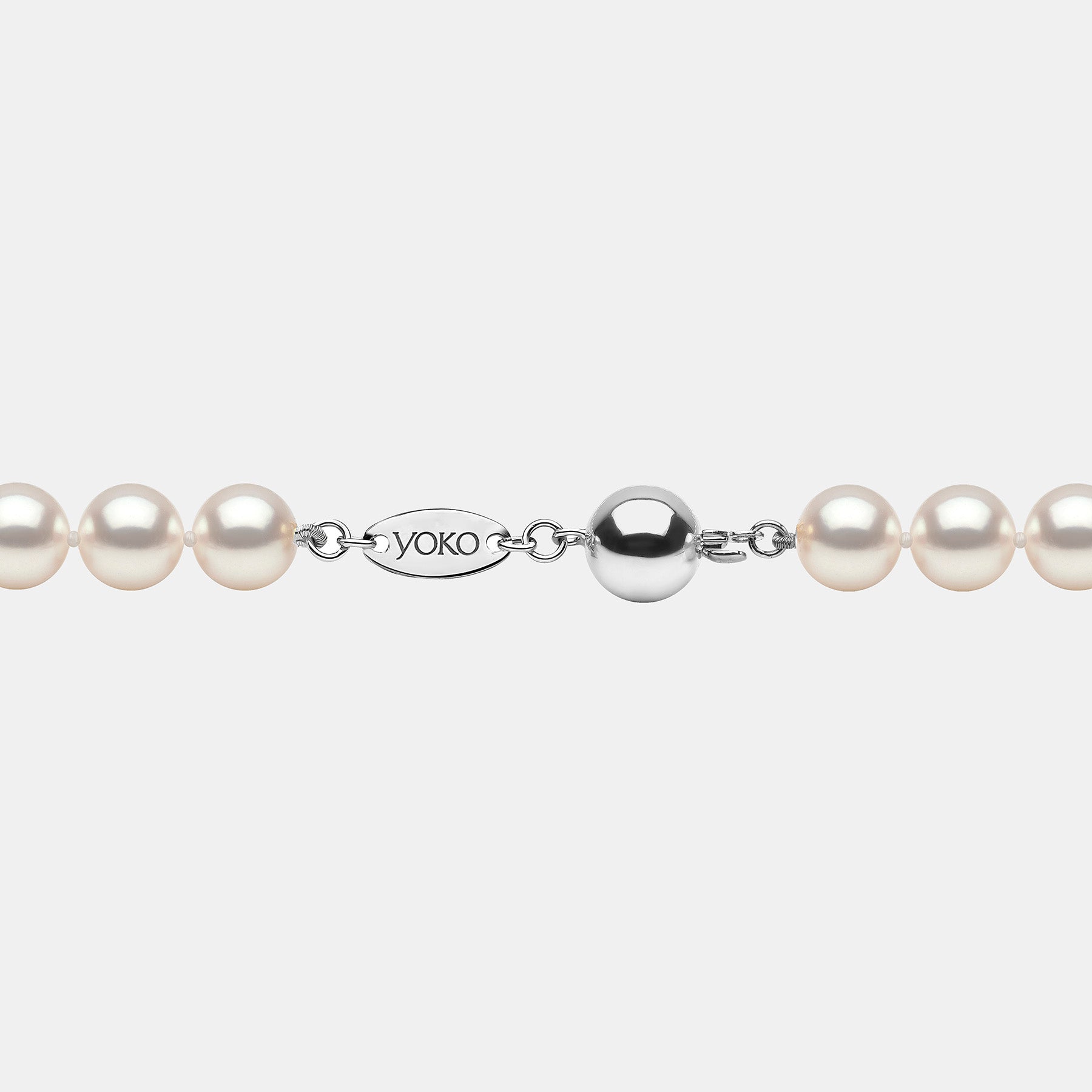 Pearl necklace with silver clasp on a grey background
