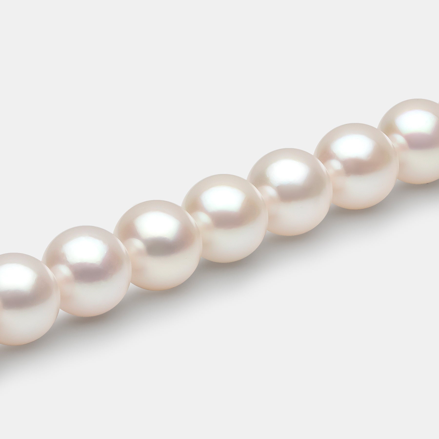 Closeup of pearl strand necklace on grey background