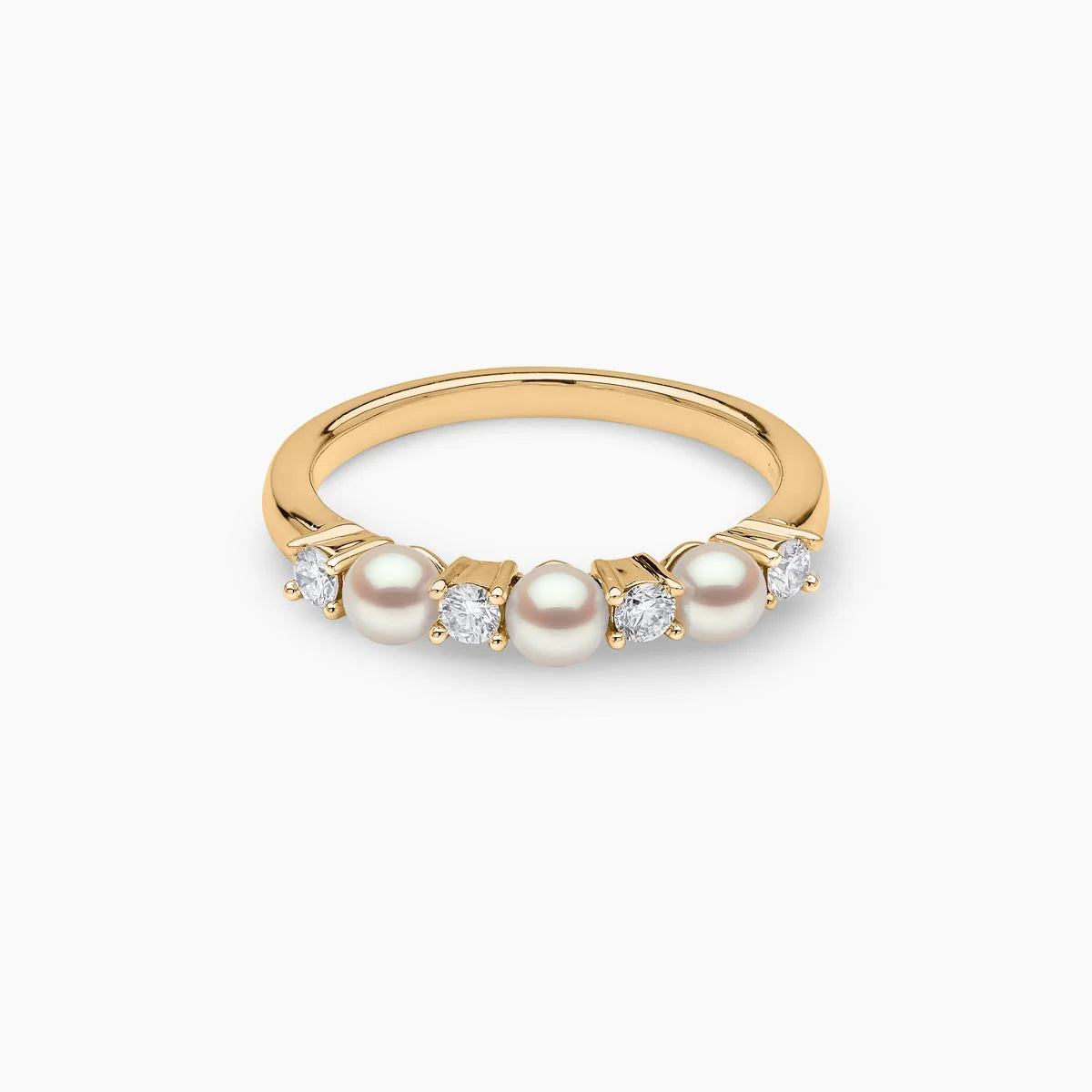 Yellow gold pearl and diamond ring on grey background, laying flat view